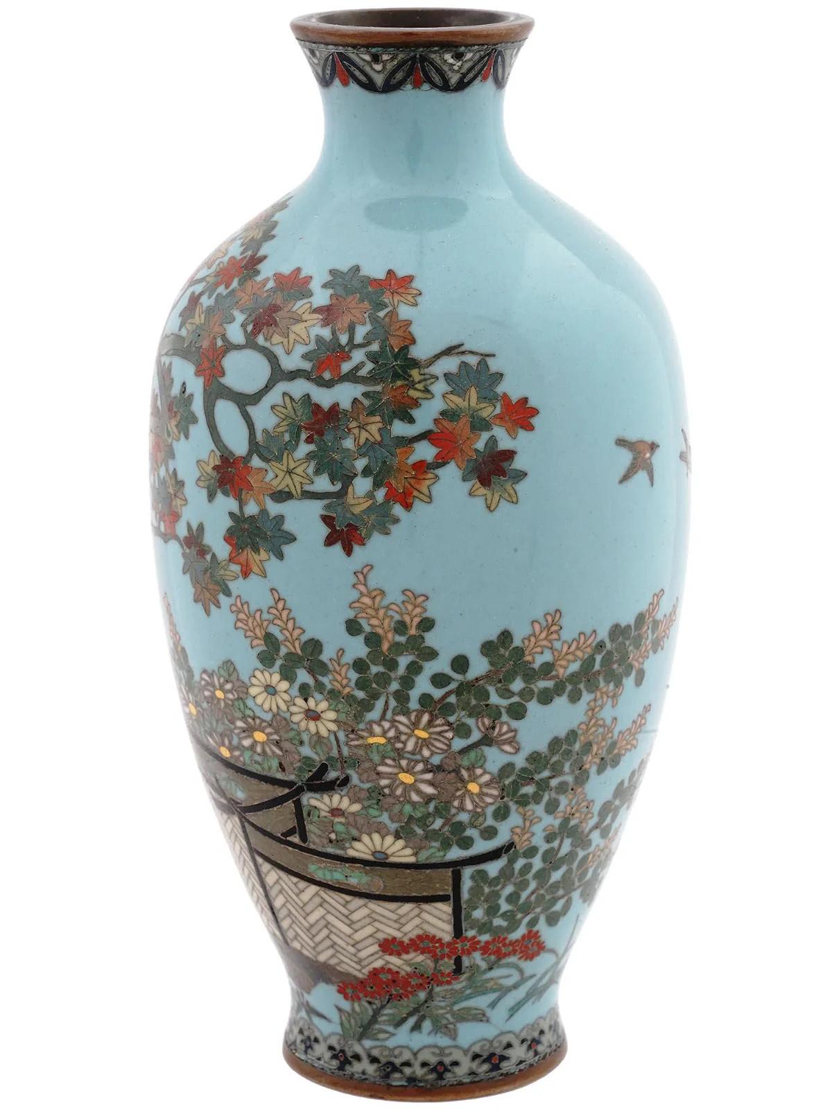 A high quality Japanese, late Meiji era, silver wire and enamel vase. The amphora shaped vase is adorned with polychrome enamel images of birds, trees, blossoming flowers, and screens. The base and the neck feature foliage, floral, and scrollwork
