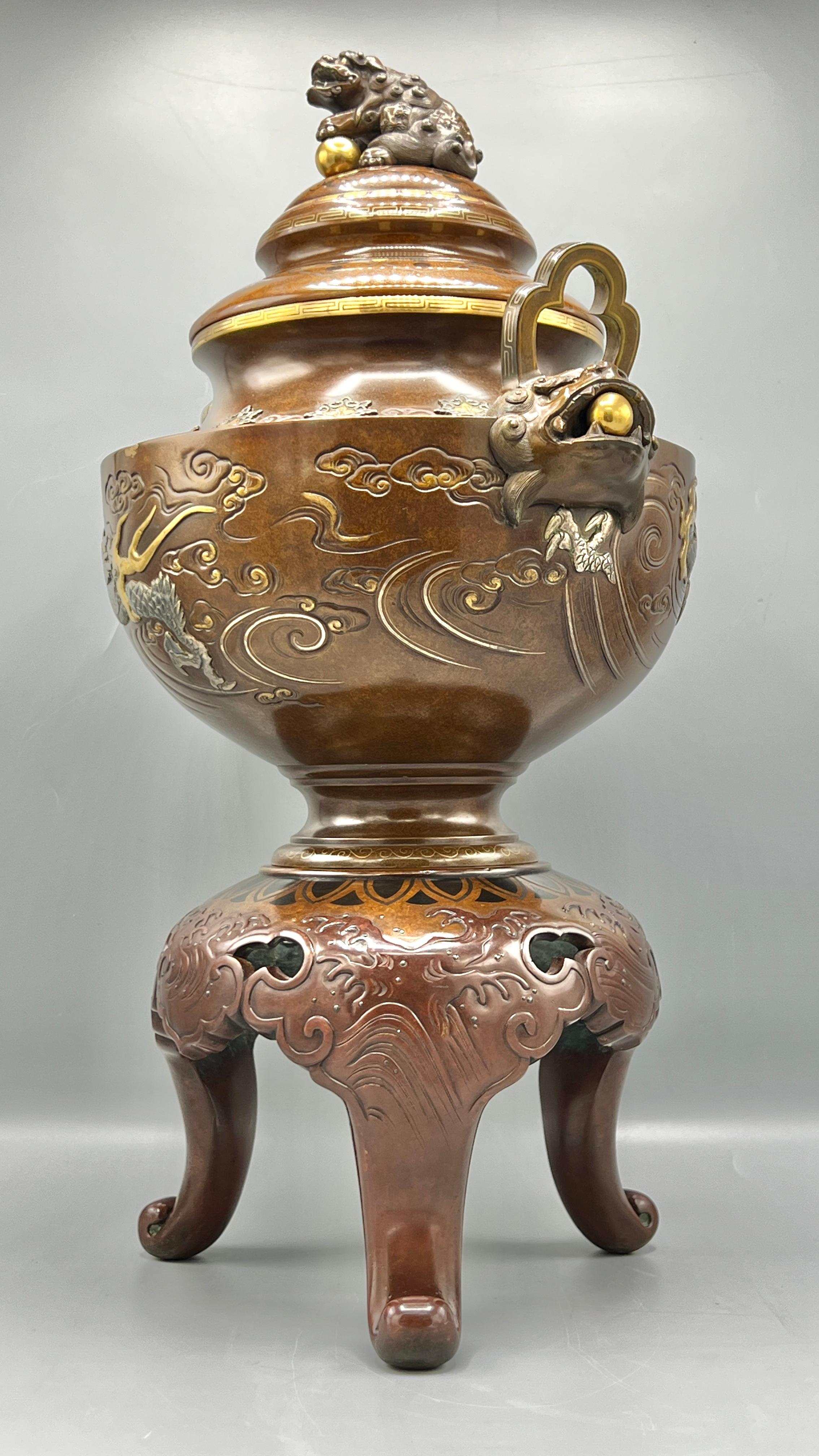 Meiji period Japanese koro censer (incense burner) exhibiting the finest craftsmanship.  Cast in bronze in three sections including base, burner and cover, with light brown patina with inlaid designs in gold and silver.  21 1/2 inches in height. 