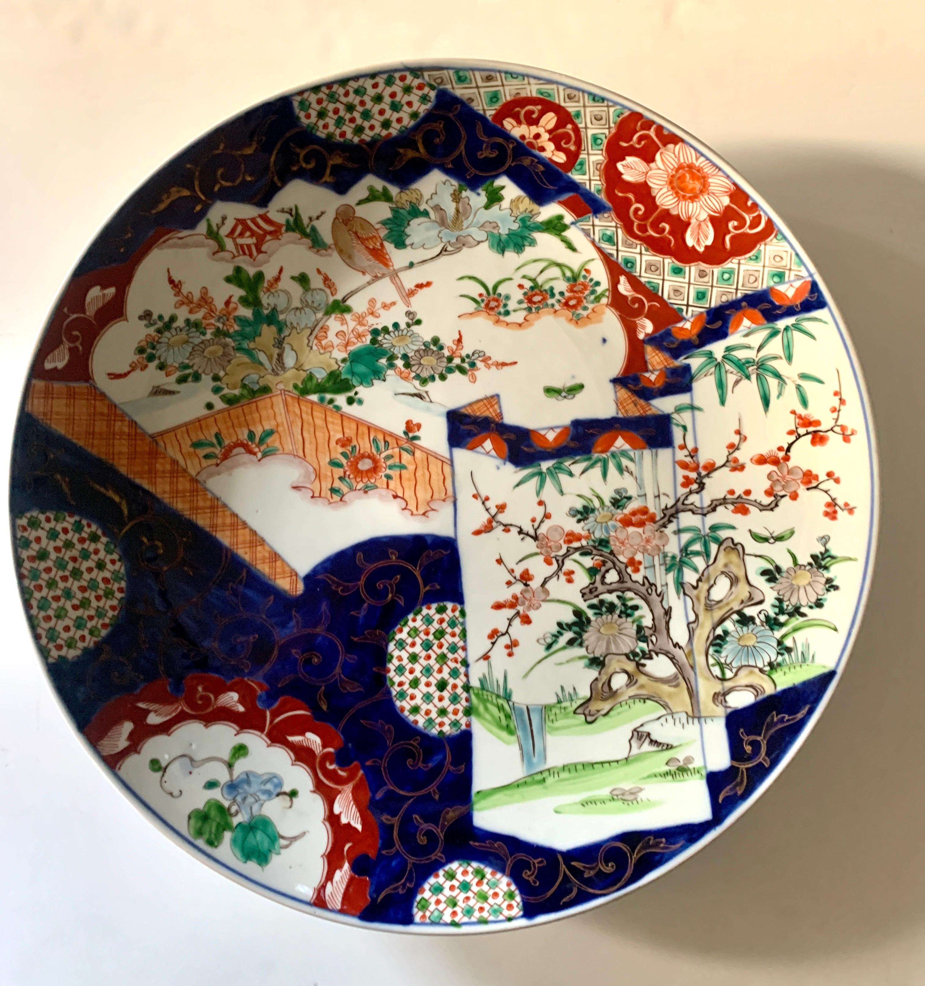 18 Inch Japanese Imari Charger - very large and decorative. The mixed illustrative painted scenes are with great pattern and texture, and mixed with floral and organic images of blossoms and nature. The plate comes with a plate hanger - ready to