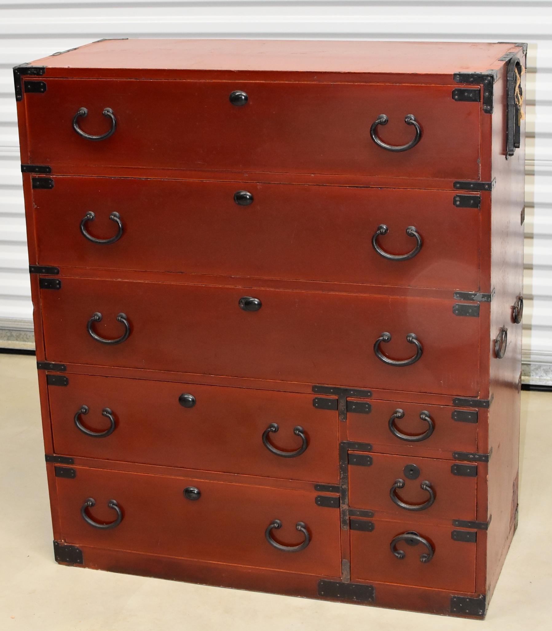 A beautiful vintage Japanese Tansu with eight full capacity drawers. The finish is an unique orange hued brown, with the dramatic contrast from the black iron hardware creates a fantastic visual impact. Original key. Retractable handles make moving