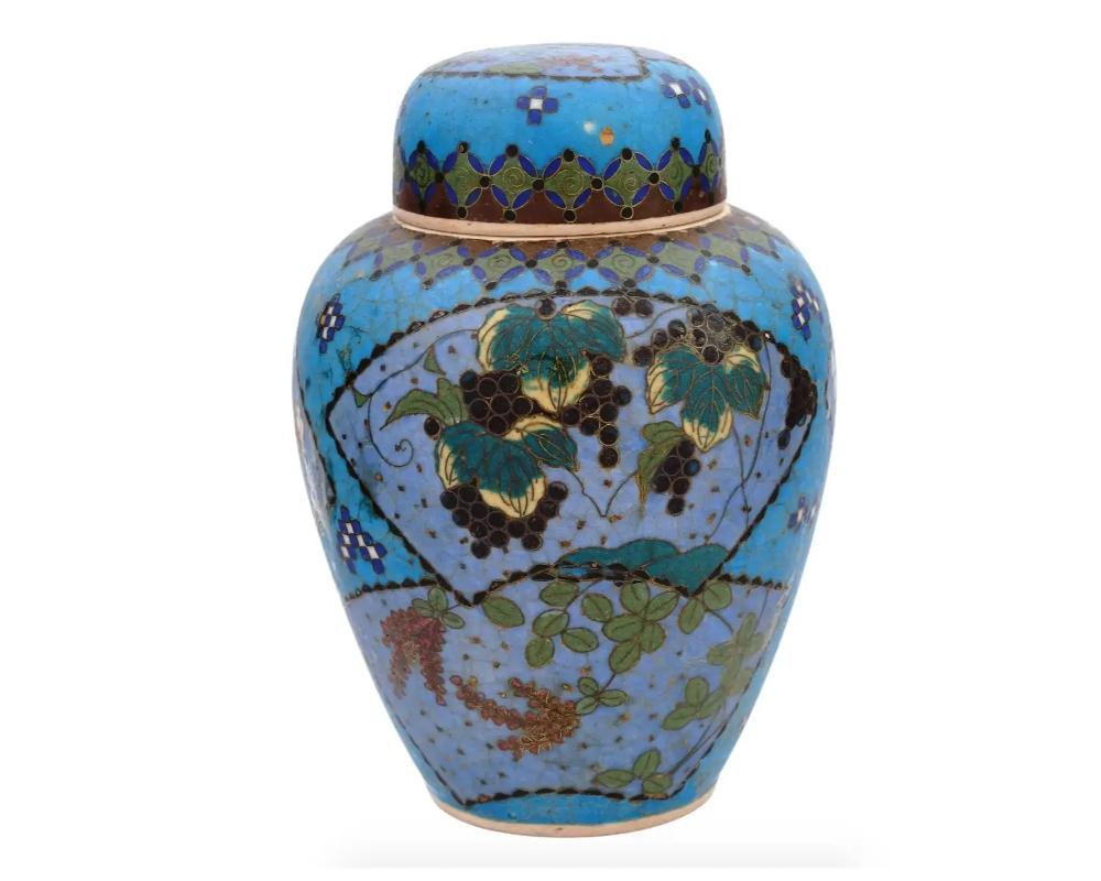 An antique Japanese late Meiji era covered Totai enamel on ceramic ginger jar. Circa: late 19th century to early 20th century. The ware is enameled with a polychrome fan shaped medallions with blossoming flowers, bamboo trees, grapes, surrounded by