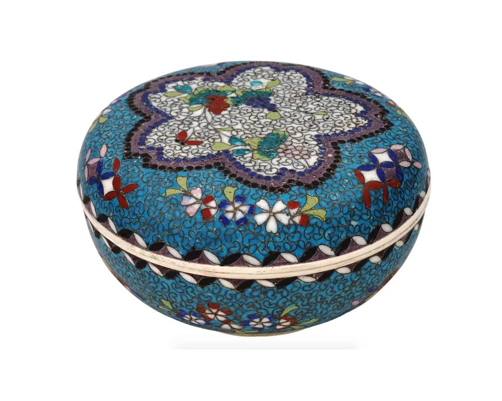 An antique Japanese late Meiji era covered Totai enamel on porcelain trinket or jewelry box. Circa: late 19th century to early 20th century. The ware is enameled with a polychrome floral medallion with butterflies and berries, on the top of the