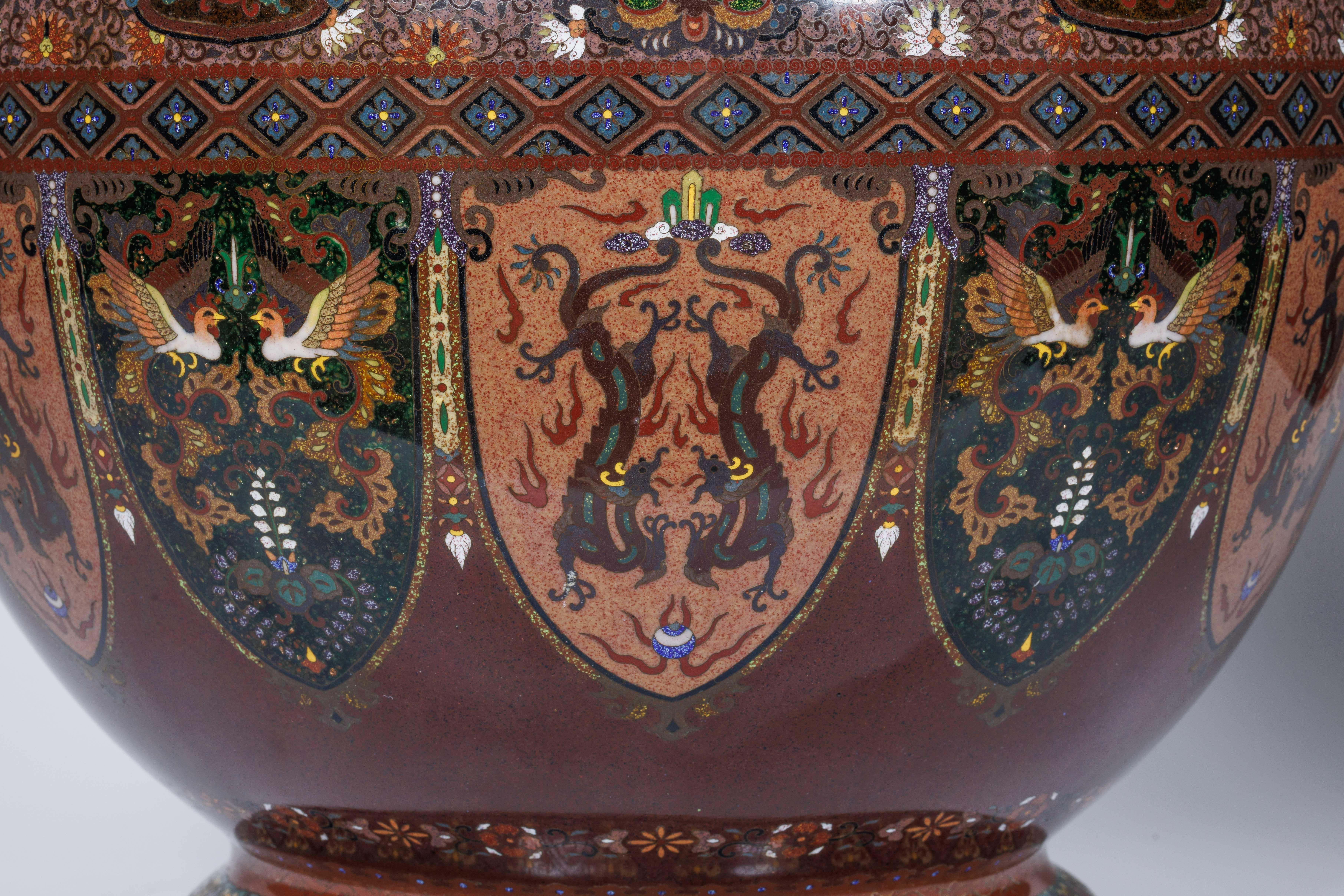 Meiji Masterpiece attributed to Ando Jubei: A Maroon Cloisonné Vase with Dragons & Phoenix, circa 1895

This monumental Meiji period Japanese cloisonné vase, attributed to the esteemed Ando Jubei workshop, stands as a quintessential example of the