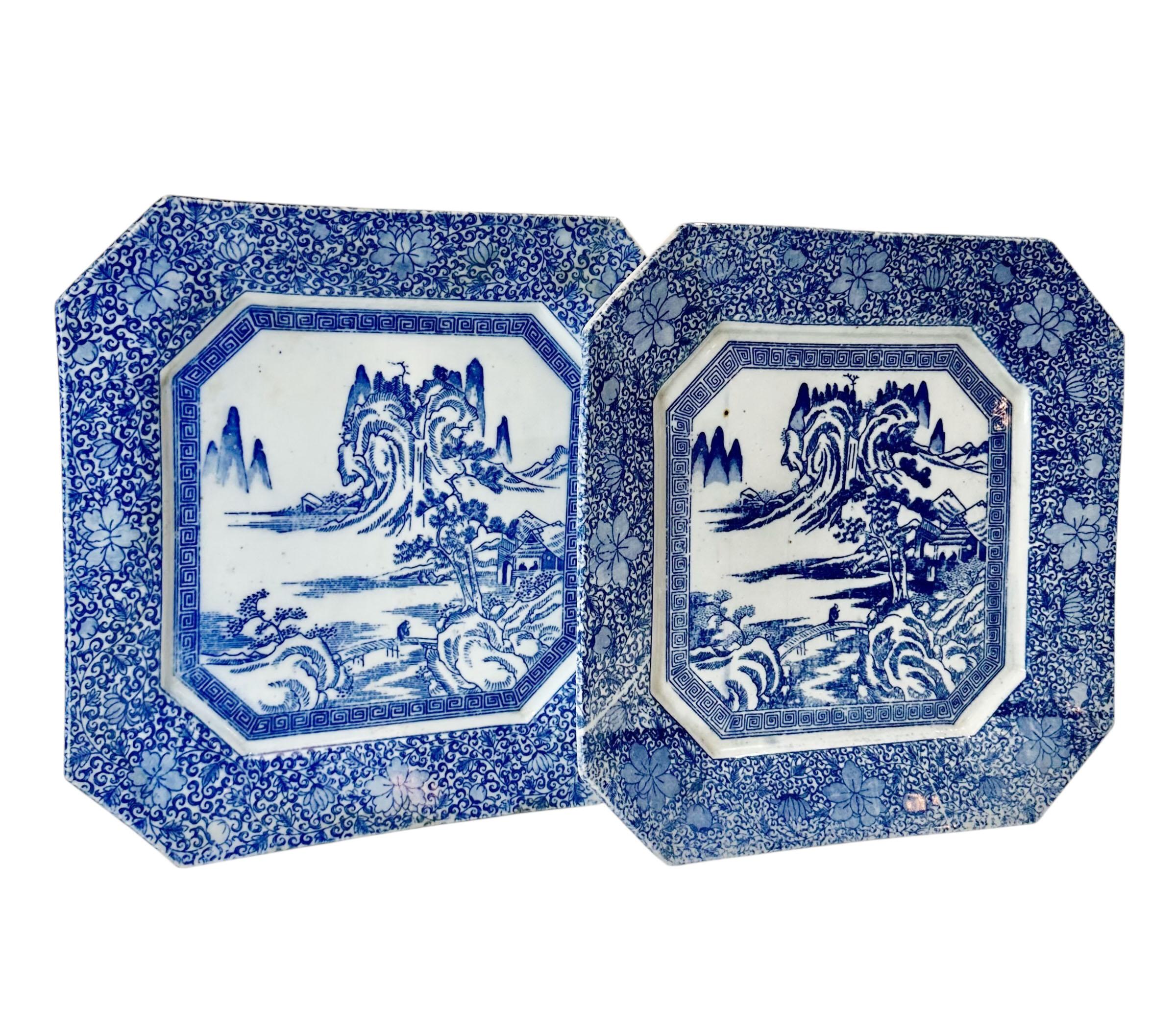 Ein auffälliges Paar großer japanischer blau-weißer Porzellanteller aus der Meiji-Periode (1868-1912) mit einer charakteristischen quadratischen Form mit abgeschnittenen Ecken. 

Diese Stücke weisen ein klassisches blaues Transferdekor auf der