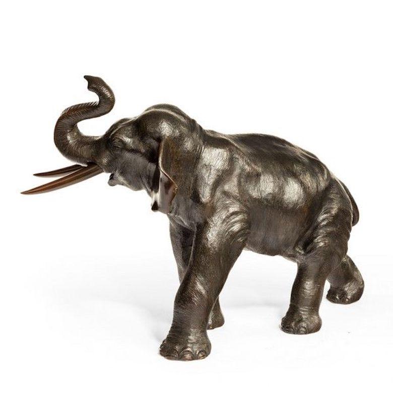 Meiji period bronze elephant striding forward with his trunk raised over his head, signed.