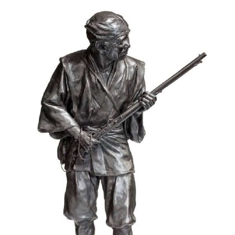Un bronze de la période Meiji représentant un chasseur portant un fusil,
Signé dans un sceau. ? ?? dans une écriture de sceau élaborée,
Qui se lit 