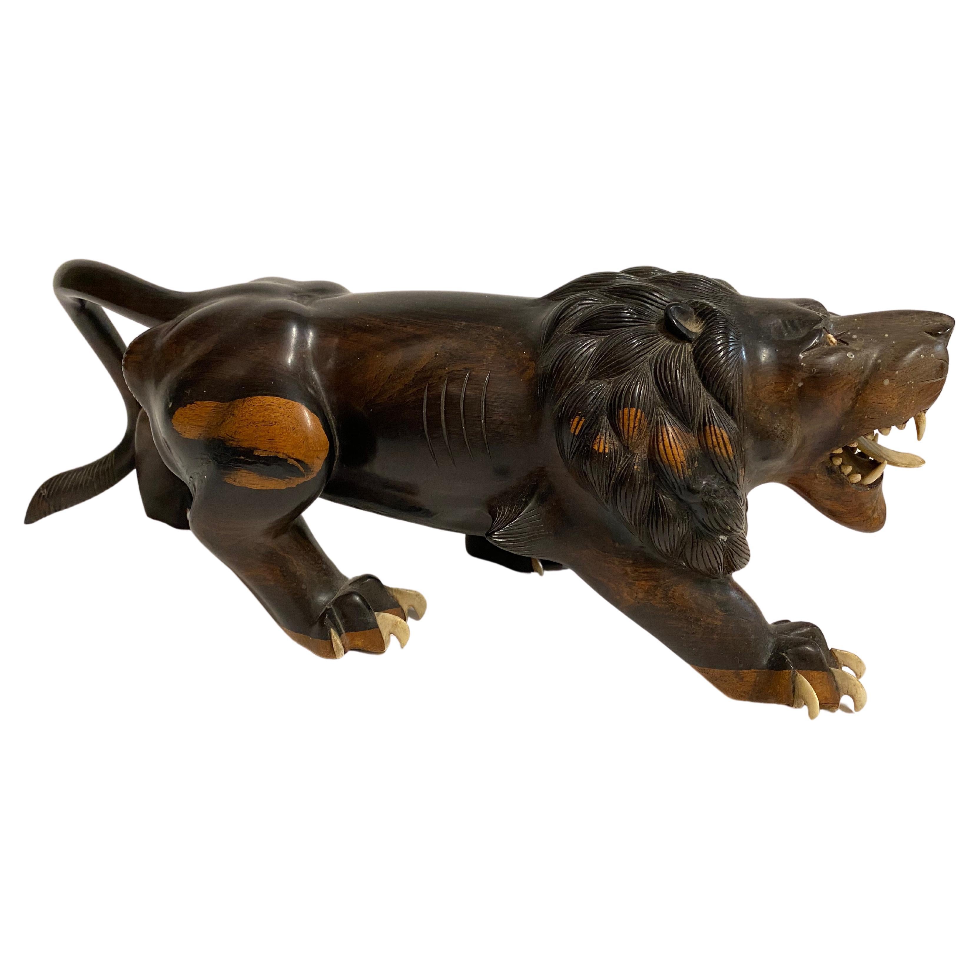 This is an outstanding pair of Meiji Period carved hardwood figures of a ferocious lion and tiger. The carving is exceptional as is the bone detailing of the mouthes and teeth. The finely carved paws are detailed with realistic bone claws; a few of