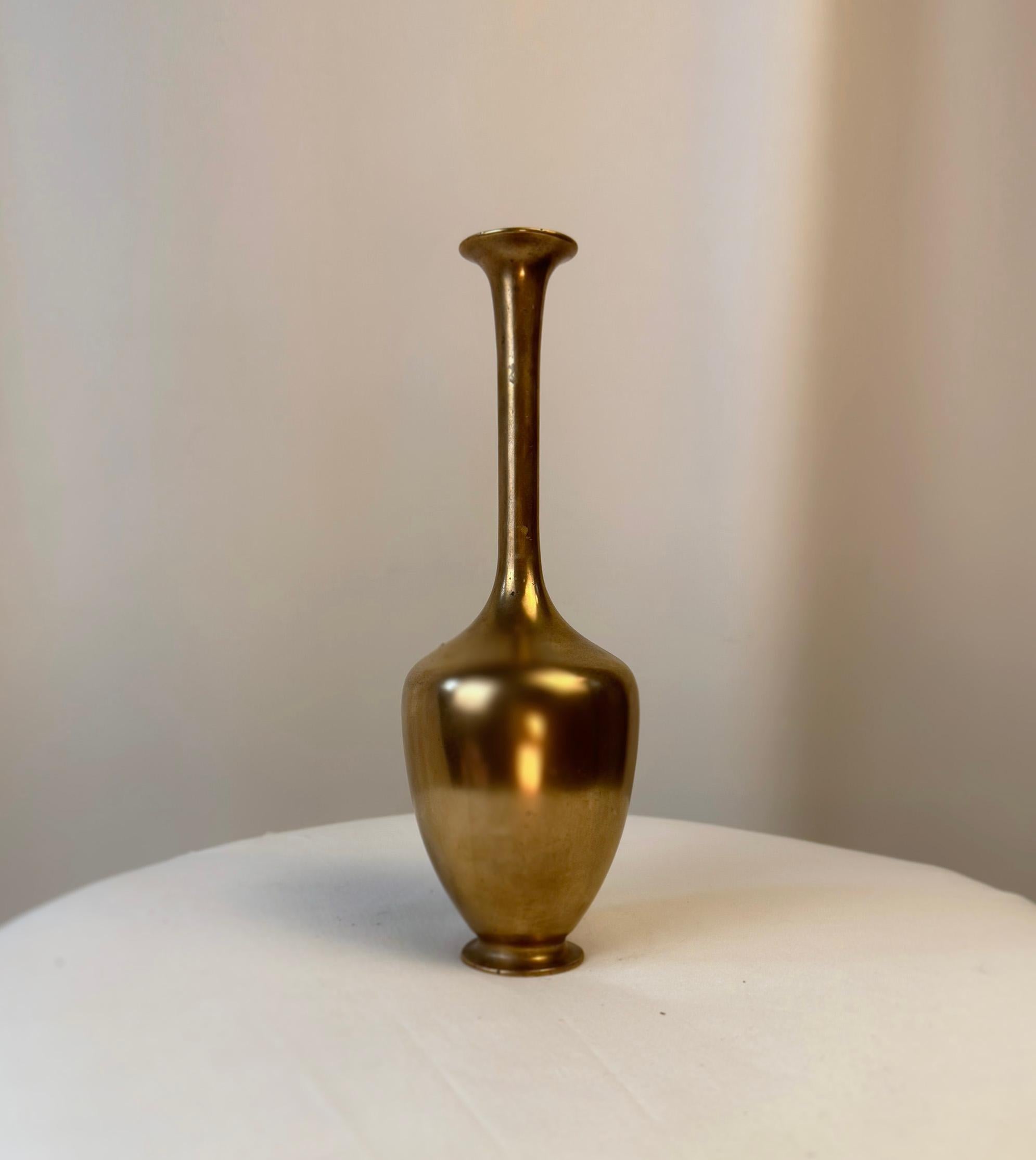 Vase en métal japonais, créé par le célèbre artisan Genryusai Seiya.

Ce vase exquis témoigne de l'artisanat raffiné de l'ère Meiji, période connue pour son épanouissement artistique au Japon. Fabriqué en cuivre, ce petit vase Ikebana incarne la