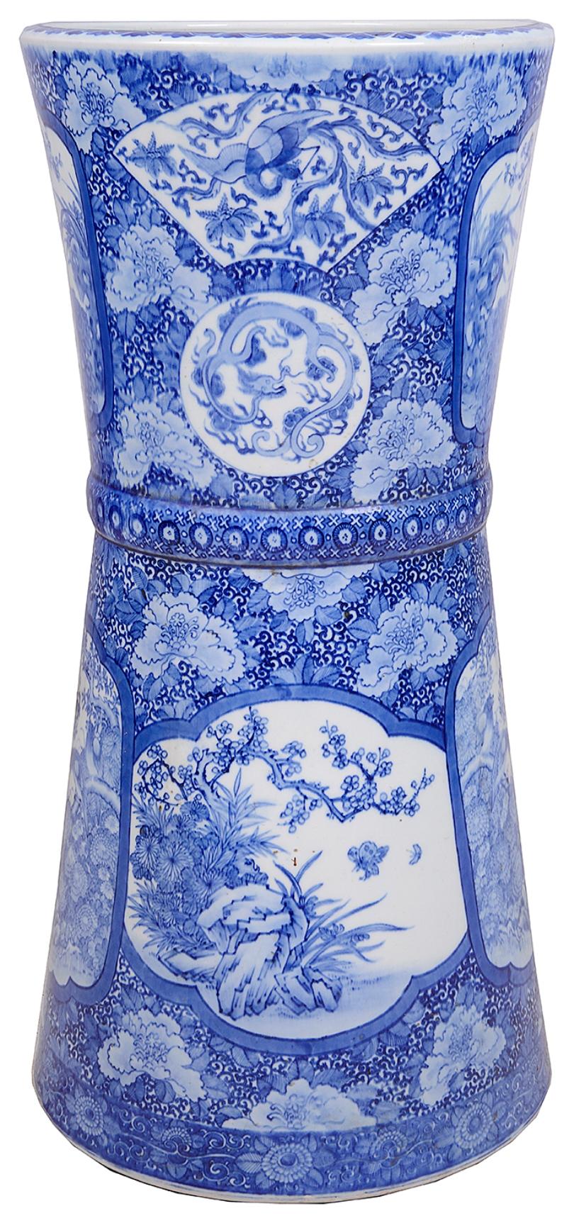 A good quality late circa 19th century, Meiji period (1868-1912) Japanese blue and white stick stand. Having hand painted panels depicting exotic birds in trees, mythical dragons, flowers and foliage and motifs, of graduating circular form.