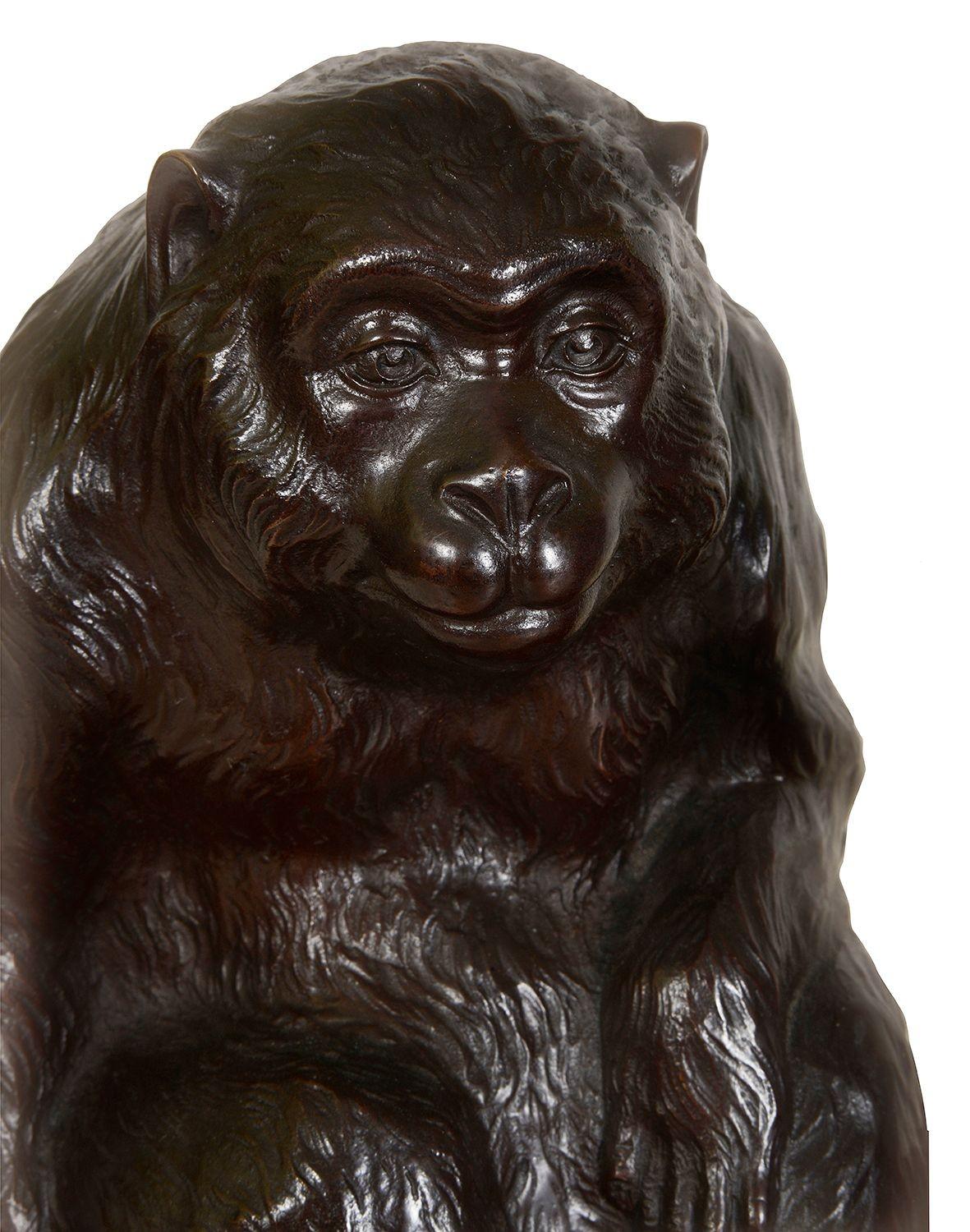 Ces sculptures japonaises exquises de la période Meiji représentent deux singes en bronze patiné, mettant en valeur l'art et l'artisanat de l'époque. Le grand singe, assis avec une expression contemplative, contraste avec le petit personnage plus
