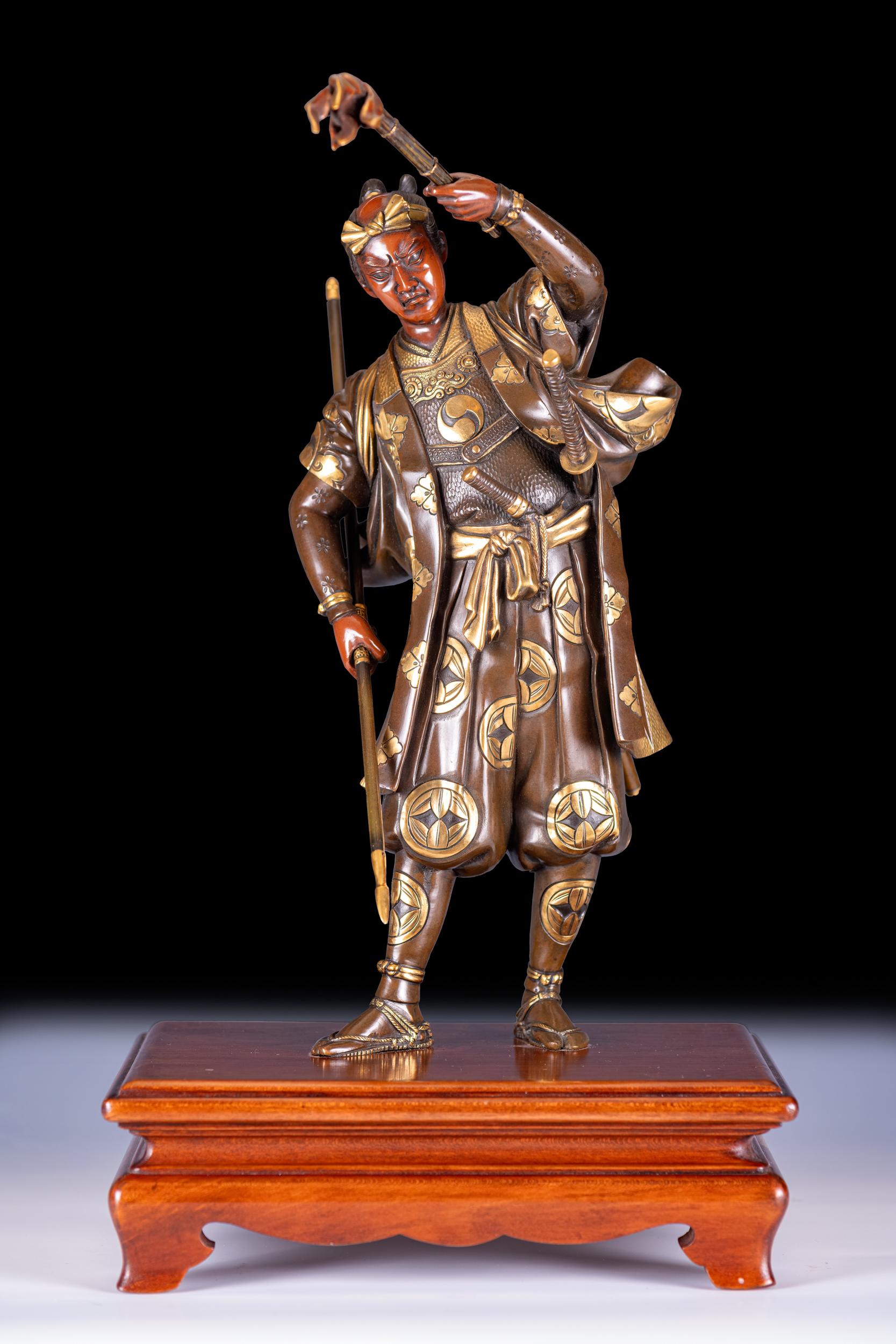 Una superba scultura giapponese in bronzo e dorato di un guerriero samurai, periodo Meiji. Raffigura un guerriero giapponese in abito nazionale e movimento impetuoso, i dettagli dorati mon (stemma araldico) finemente lavorati su un fondo di ricca