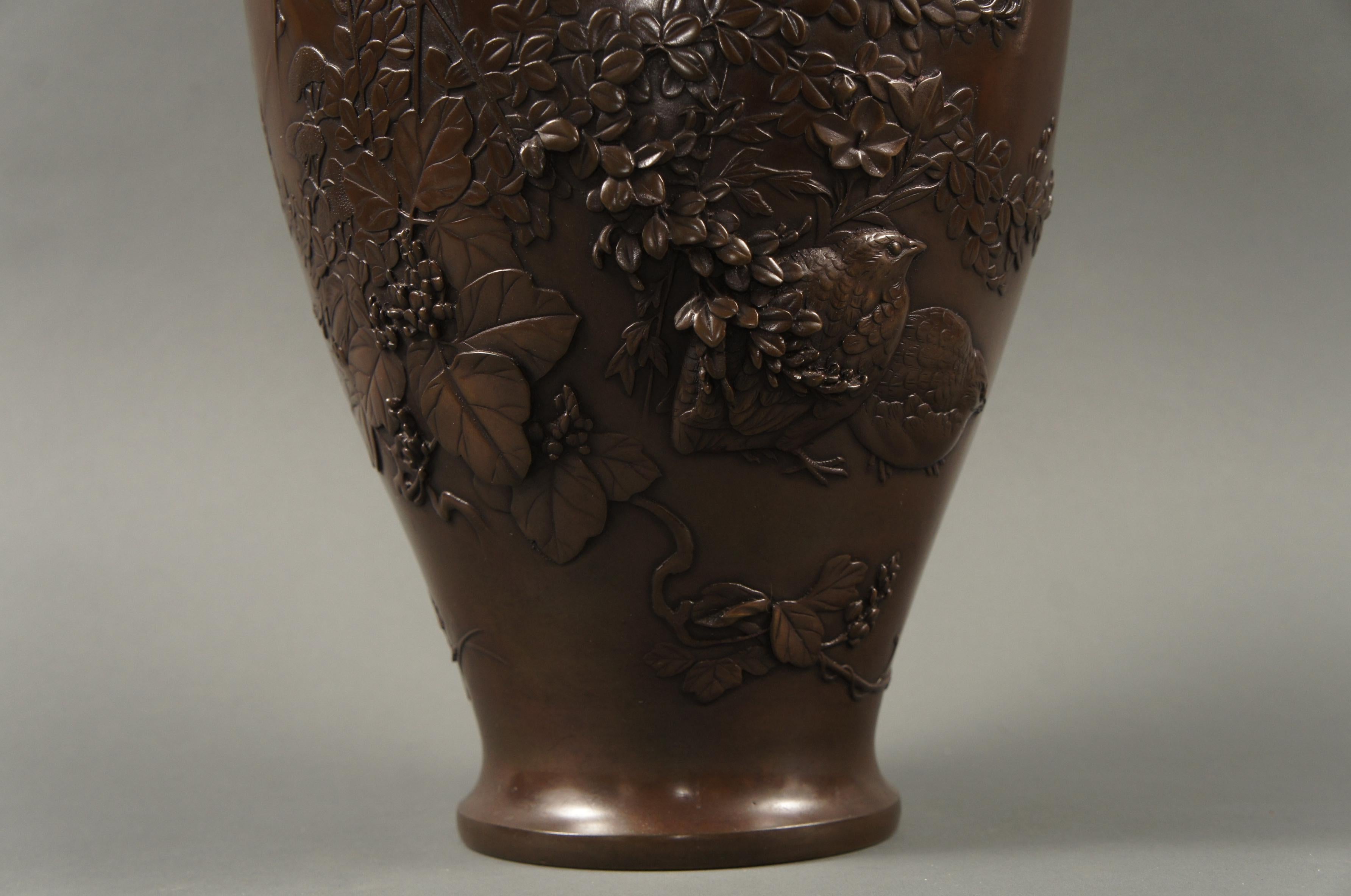 Meiji Japanese bronze vase with grasses and Quail design, Meiji period (1868-1912) bronze vase with elaborate raised design of wild grasses, flowers, and vine partially hiding a pair of quail. Beautiful composition. Artist seal on the bottom in the