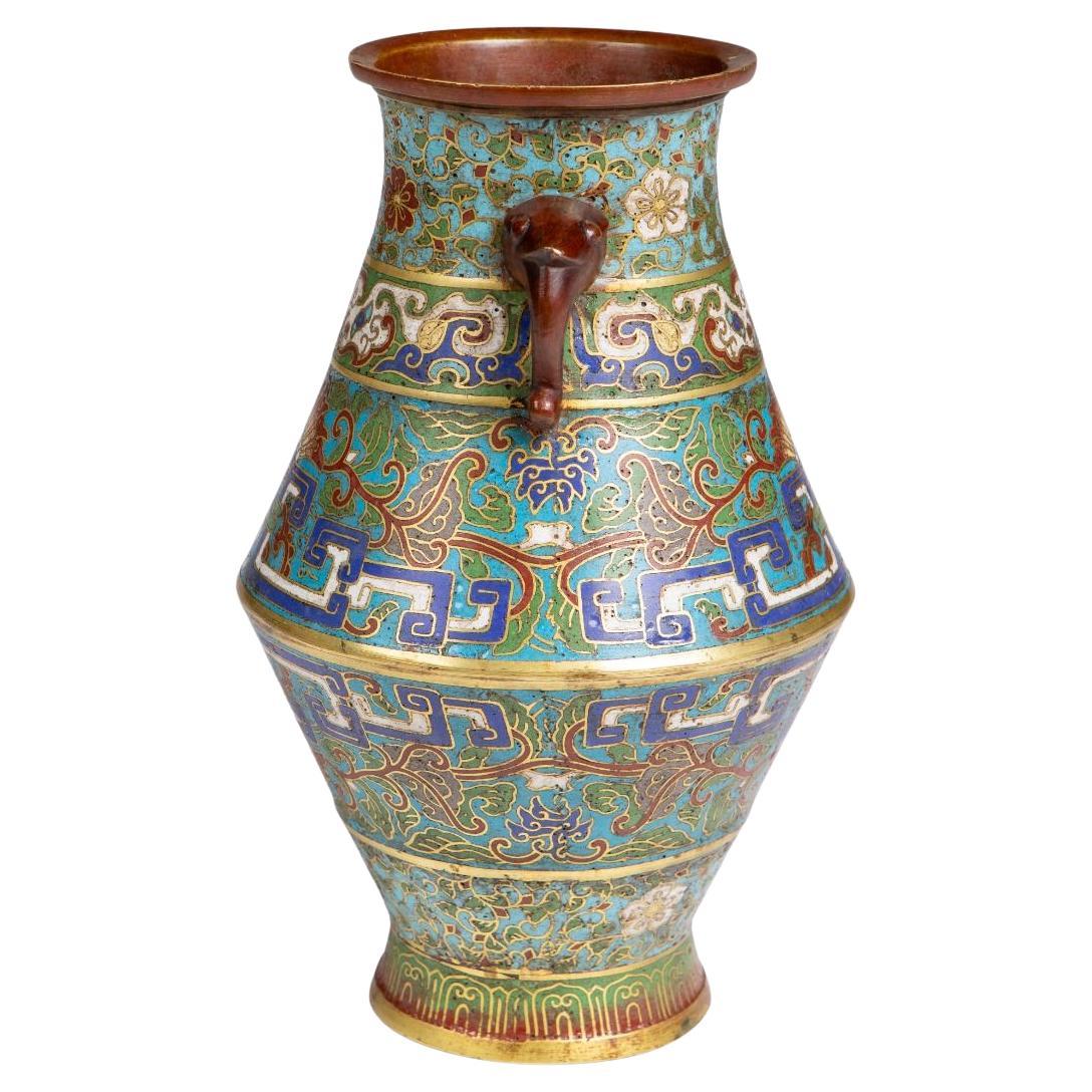 Japanese cloisonné vase from the Meiji period.
Brass body decorated with polychrome enamel in blue, green, white and iron red on a turquoise ground. Ornamented with floral and foliate designs, geometric borders and stylised motifs, executed in