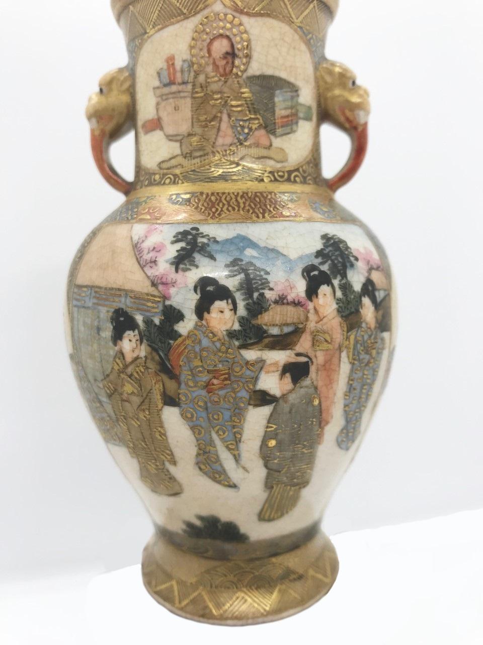 This is an exquisite miniature Japanese Satsuma vase from the Meiji period (1868-1911). It is superbly decorated with various shaped figures in cartouches in front and on the reverse on a brocade patterned base. Two Foo dog handles are applied. It