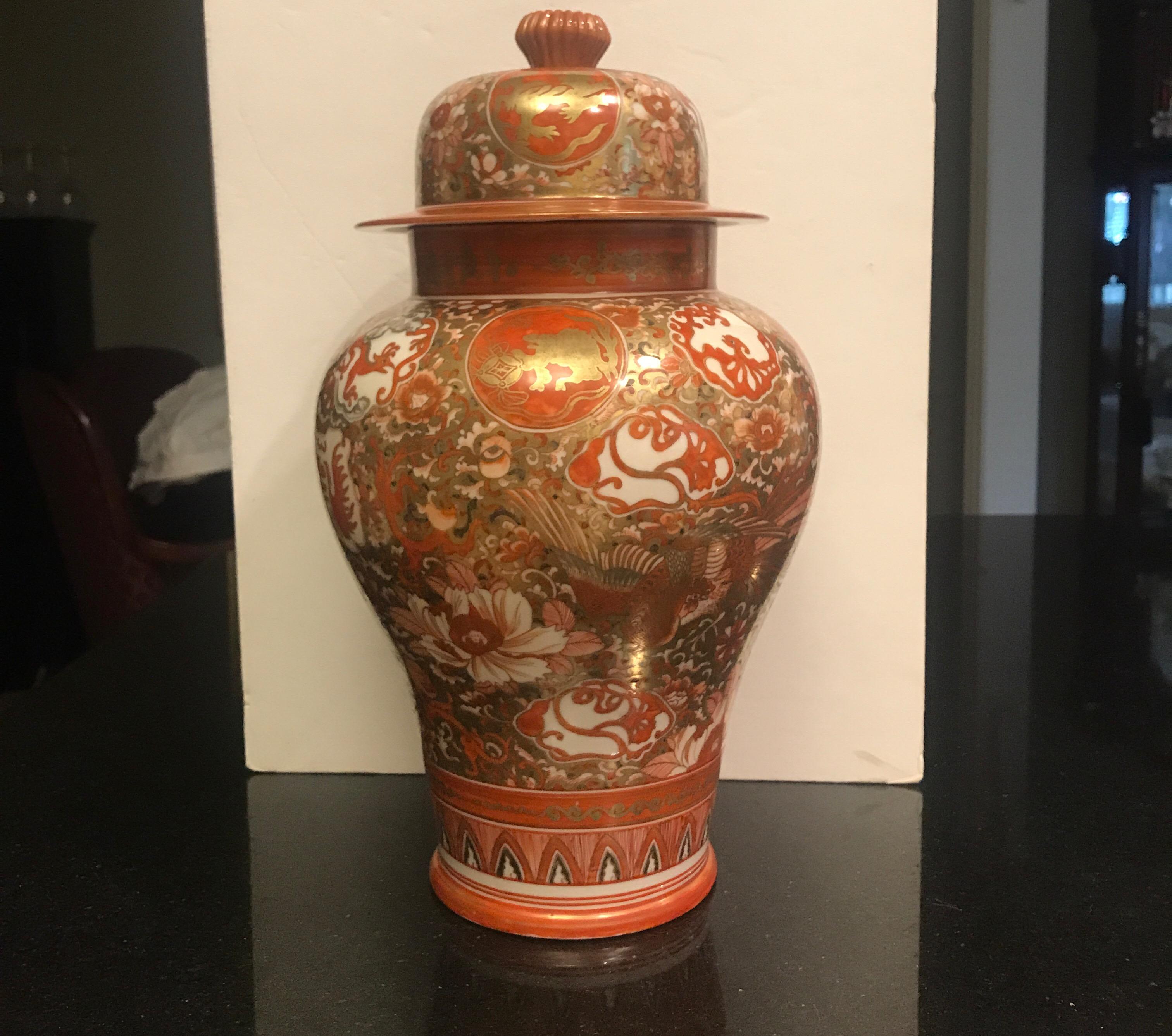 Antique Meiji period Japanese porcelain temple jar with intricate hand painted decoration and gilt. The jar in Classic Kutani colors with floral and phoenix birds all over the top and jar.