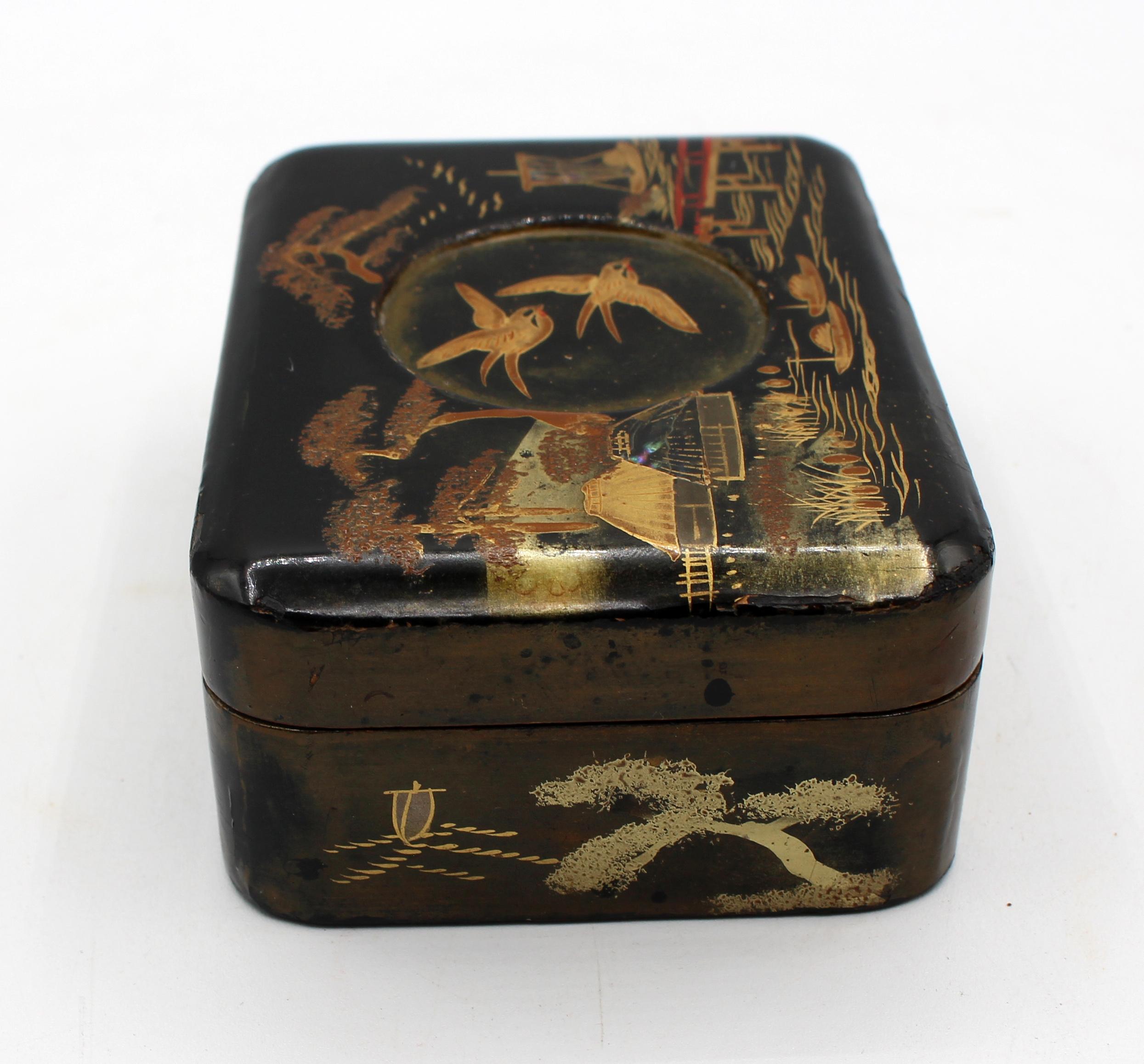 Petite boîte en laque d'époque Meiji avec couvercle à charnière, japonaise. Finement décorée, elle présente des incrustations d'abalone à plusieurs endroits. Le cercle en creux représente des hirondelles en vol. De fines dorures mettent en valeur