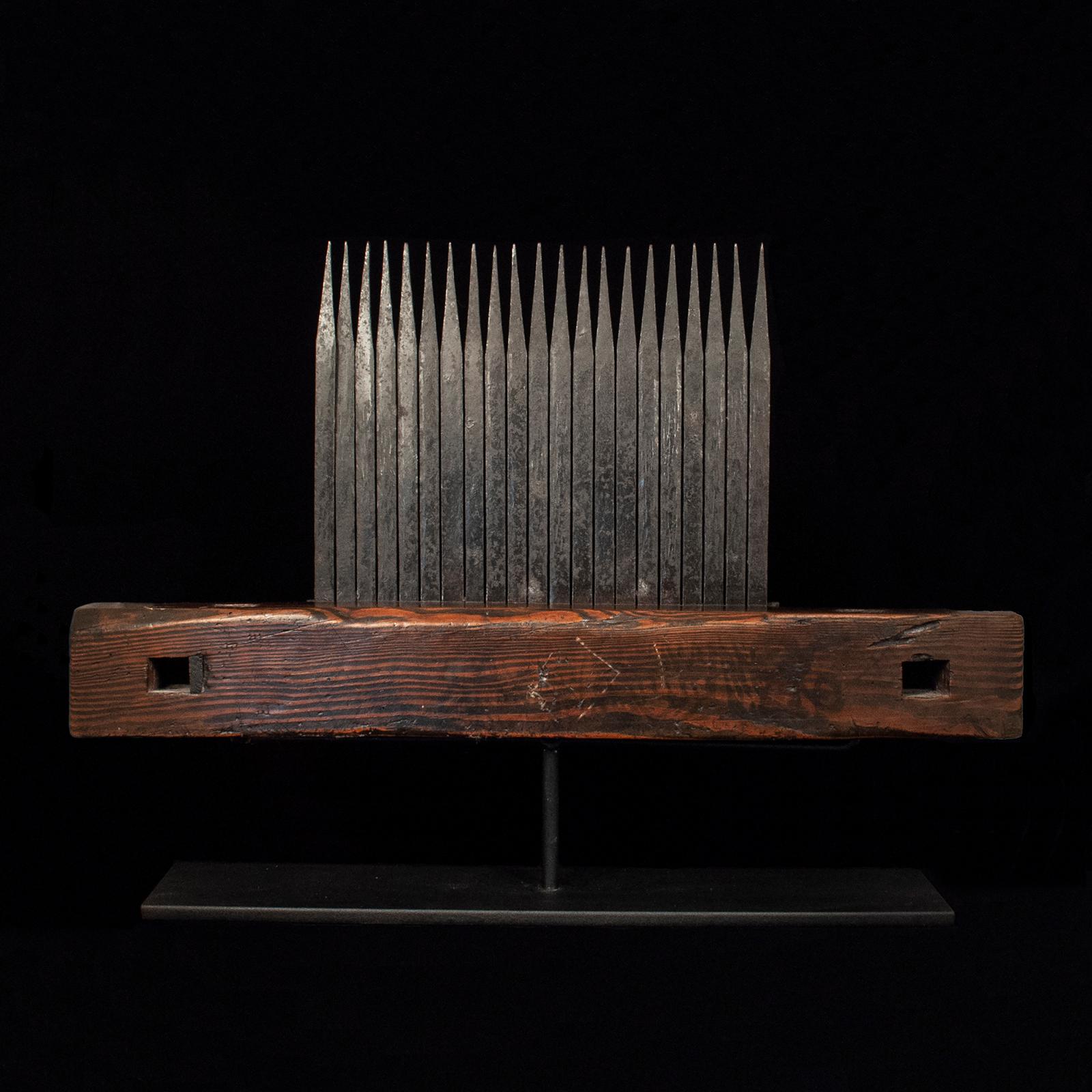 A rare large Meiji Period (1868-1912) comb used for threshing rice straw, with 21 hand forged iron tines mounted on hard wood. Displays beautifully on a custom metal base. 12.25