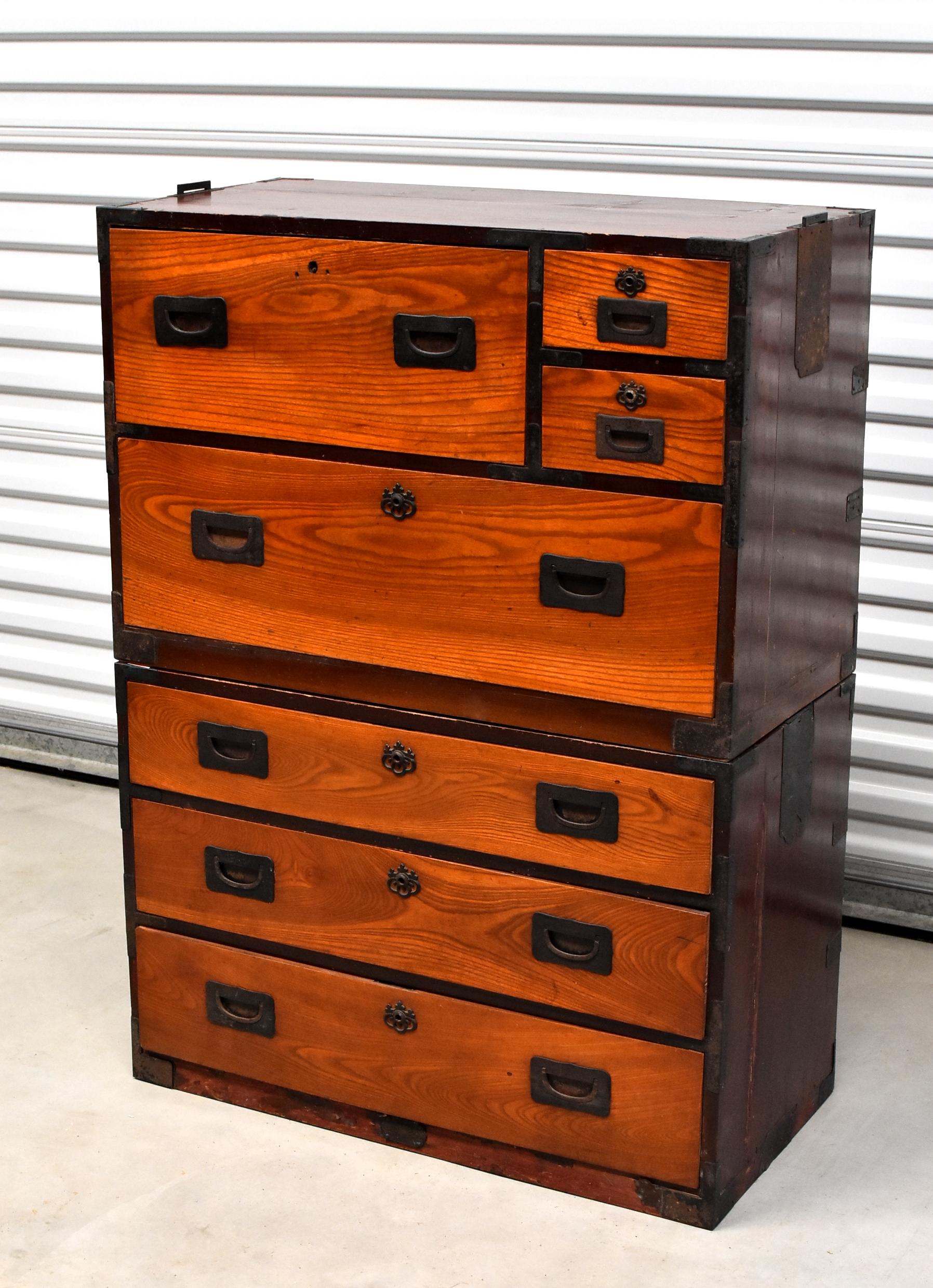 A beautiful vintage Japanese Tansu consists two individual chests that can be used separately. Beautiful, solid bronze and iron hardware. Fantastic contrast of orange and black creates great visual impact. Retractable side handles. 7 full capacity