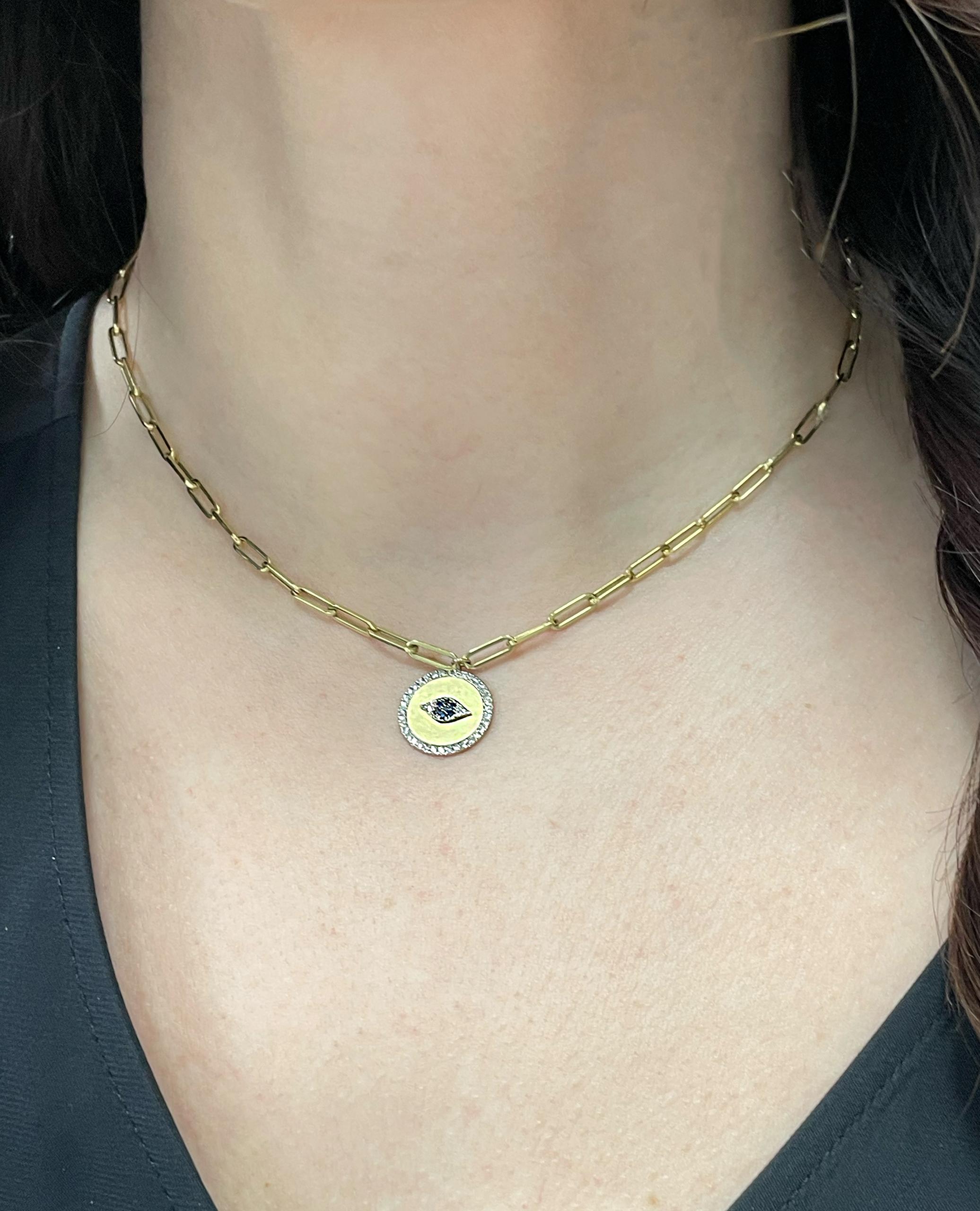Meira T. 14K yellow gold paperclip chain evil eye disc pendant necklace with diamonds weighing 0.22 carats total and blue sapphires weighing 0.05 carat total.  

- Necklace is 16 inches long. 
