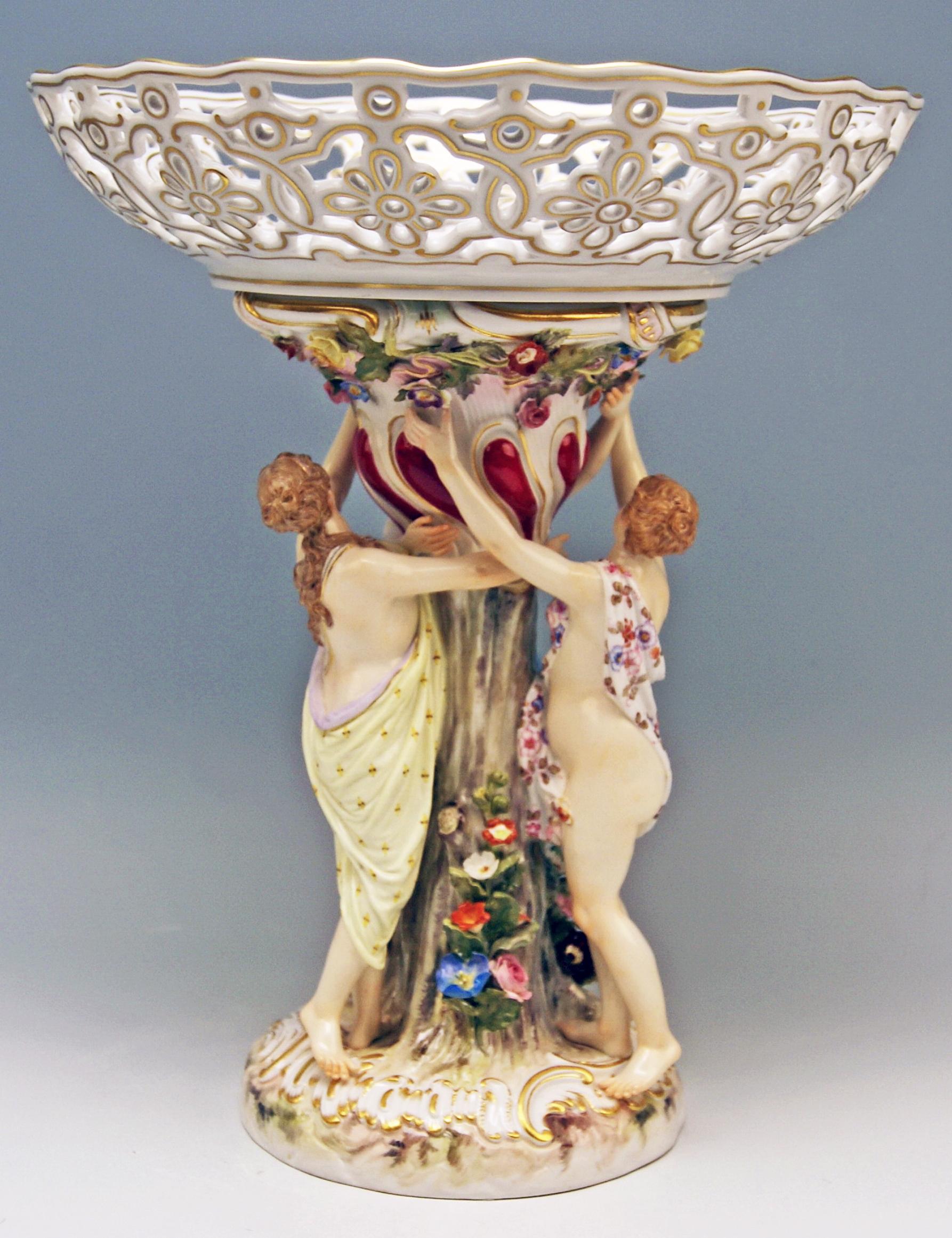 This Meissen centrepiece is manufactured in most skillful manner, having a stalk with female figurines symbolizing the Three Charities:
There is a round reticulated bowl with golden paintings existing / the bowl is attached to an excellent stalk