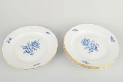 Meissen. 4 porcelain dinner plates with blue floral motifs and gilt rim.