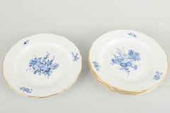Meissen. 4 porcelain lunch plates with blue floral motifs and gilt rim.