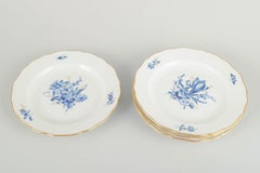 Meissen. 4 porcelain lunch plates with blue floral motifs and gilt rim.