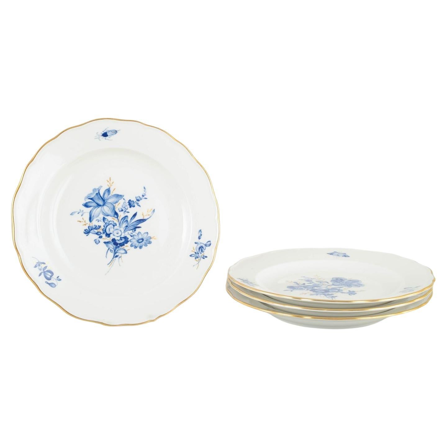 Meissen. 4 porcelain lunch plates with blue floral motifs and gilt rim.