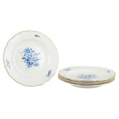 Meissen. 4 porcelain lunch plates with blue floral motifs and gilt rim.
