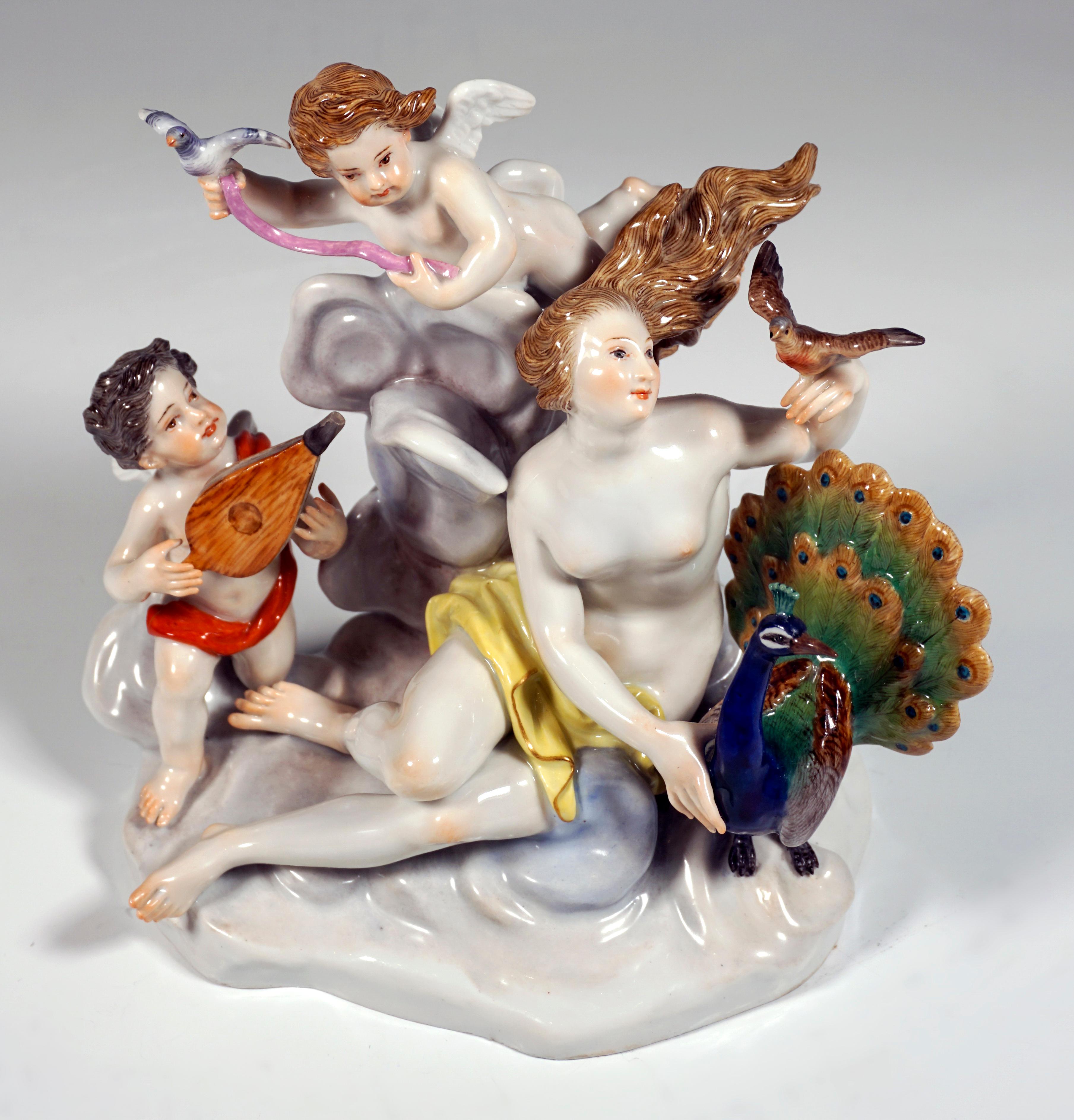 Sehr seltene Meissener Porzellangruppe aus dem 19. Jahrhundert:
Juno, die römische Göttin der Lüfte (griechisch Hera), als junge Frau mit wehendem Haar auf einer Wolke sitzend, nur mit einem Tuch bedeckt, daneben ihr Attribut, der Pfau als