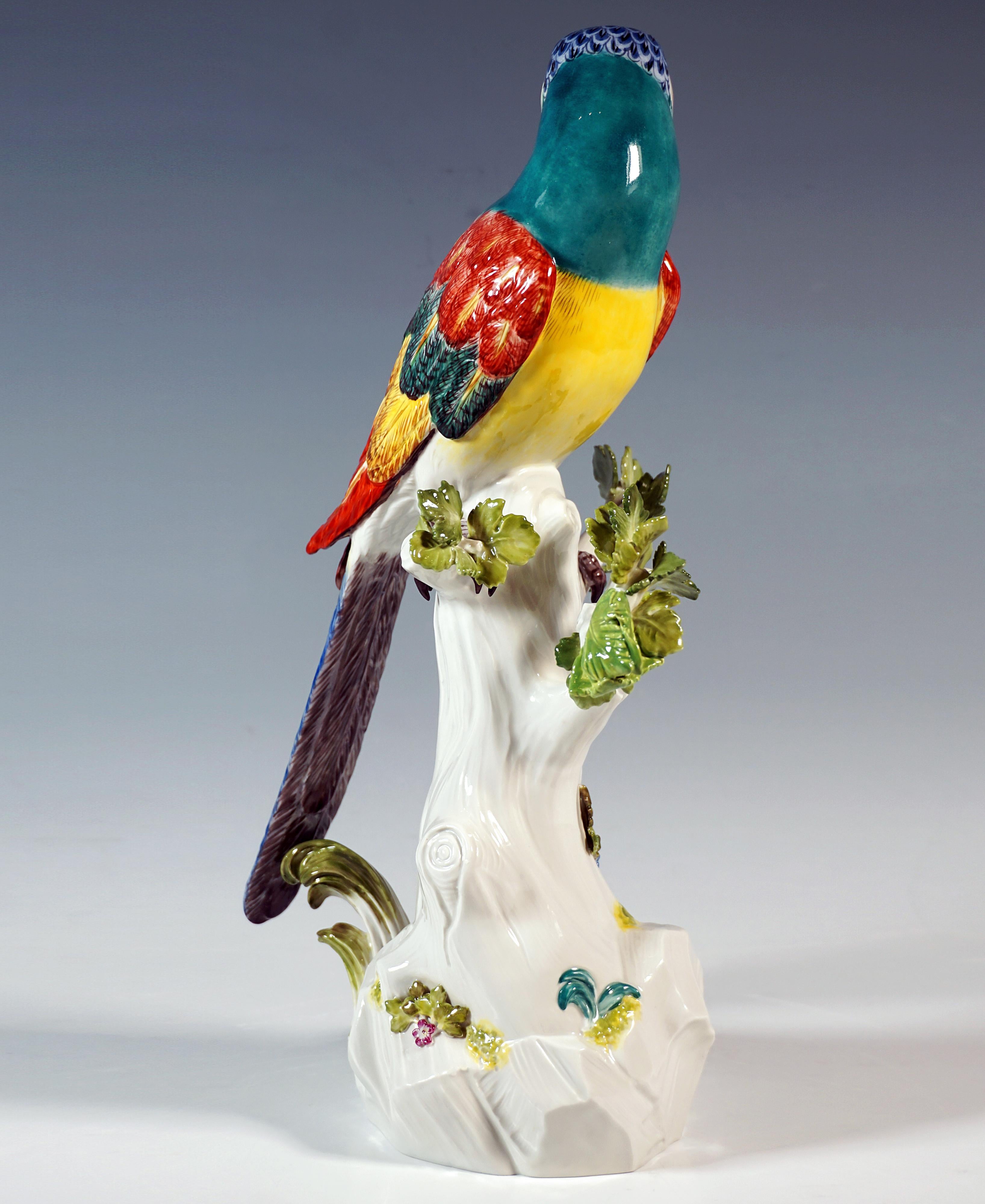 Excellent lifelike depiction of an exotic bird sitting on a sturdy tree trunk, turning its head to the left.
Detailed execution of the scenery in bold colours, base based on a heavy rock and trunk base with plastic flower and leaf decoration below