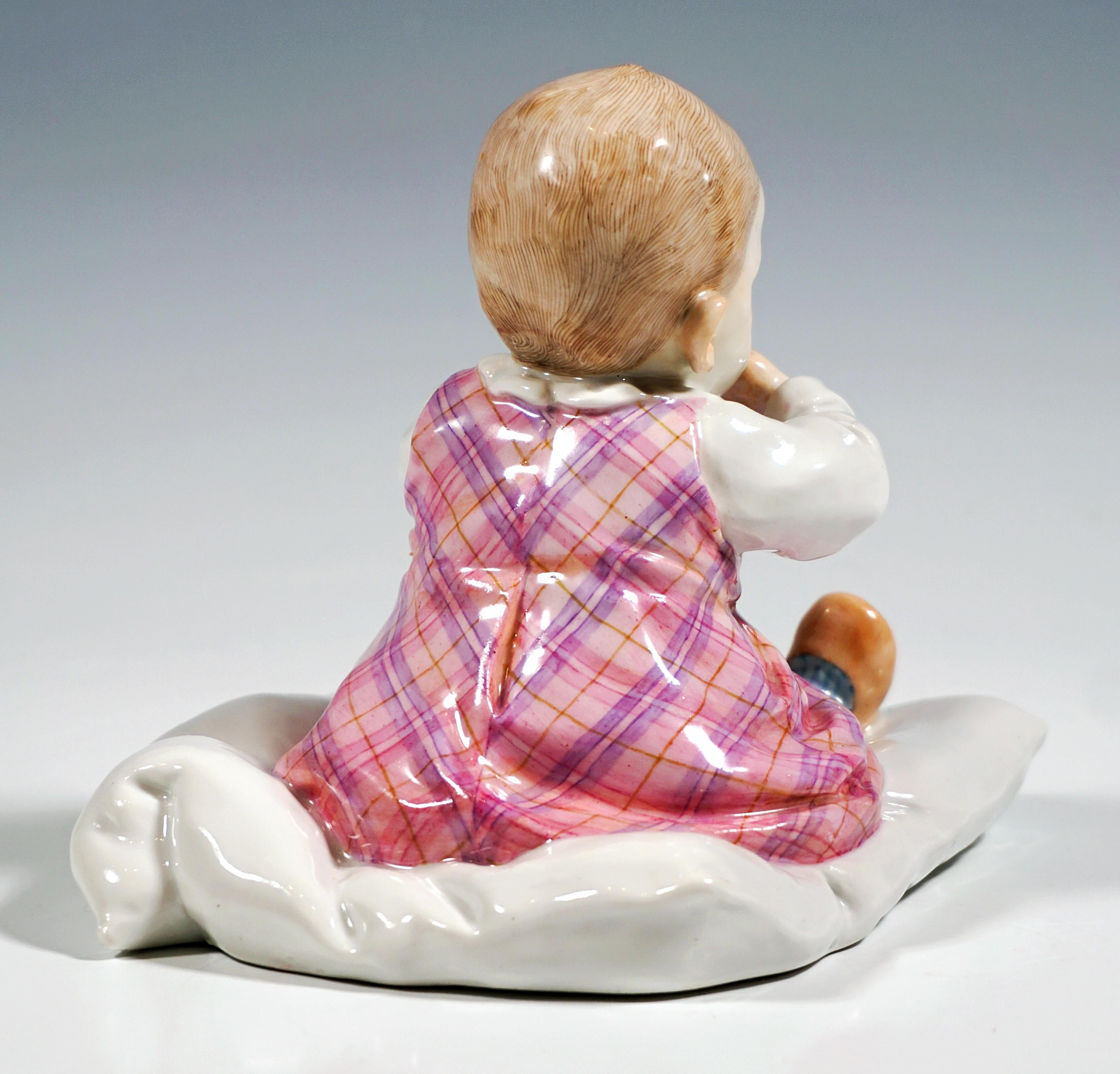 Figura in Art Nouveau Meissen Porcelain dell'epoca in cui è stato creato il modello:
Bambino con i capelli castani, vestito con i tipici abiti per bambini del 1900 circa - grembiule e camicia a maniche lunghe sotto, seduto su un cuscino con le gambe