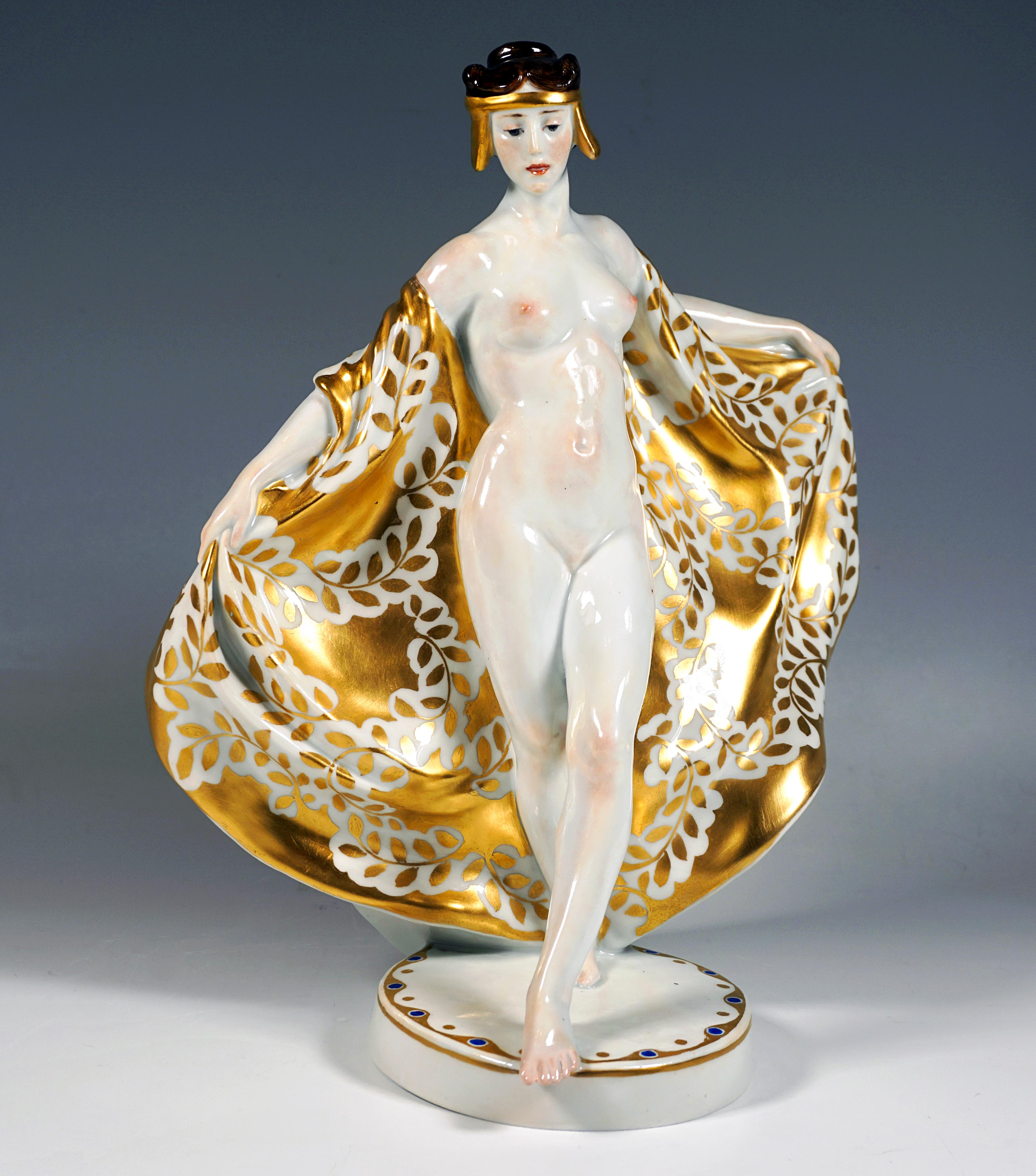 Äußerst dekorative bildhauerische Darstellung der Tänzerin Loie Fuller, unbekleidet, nur mit einem großen, weich fallenden, bodenlangen Schal mit goldenem Lorbeerzweigdekor um die Schultern drapiert, das hochgesteckte, braune, gelockte Haar mit