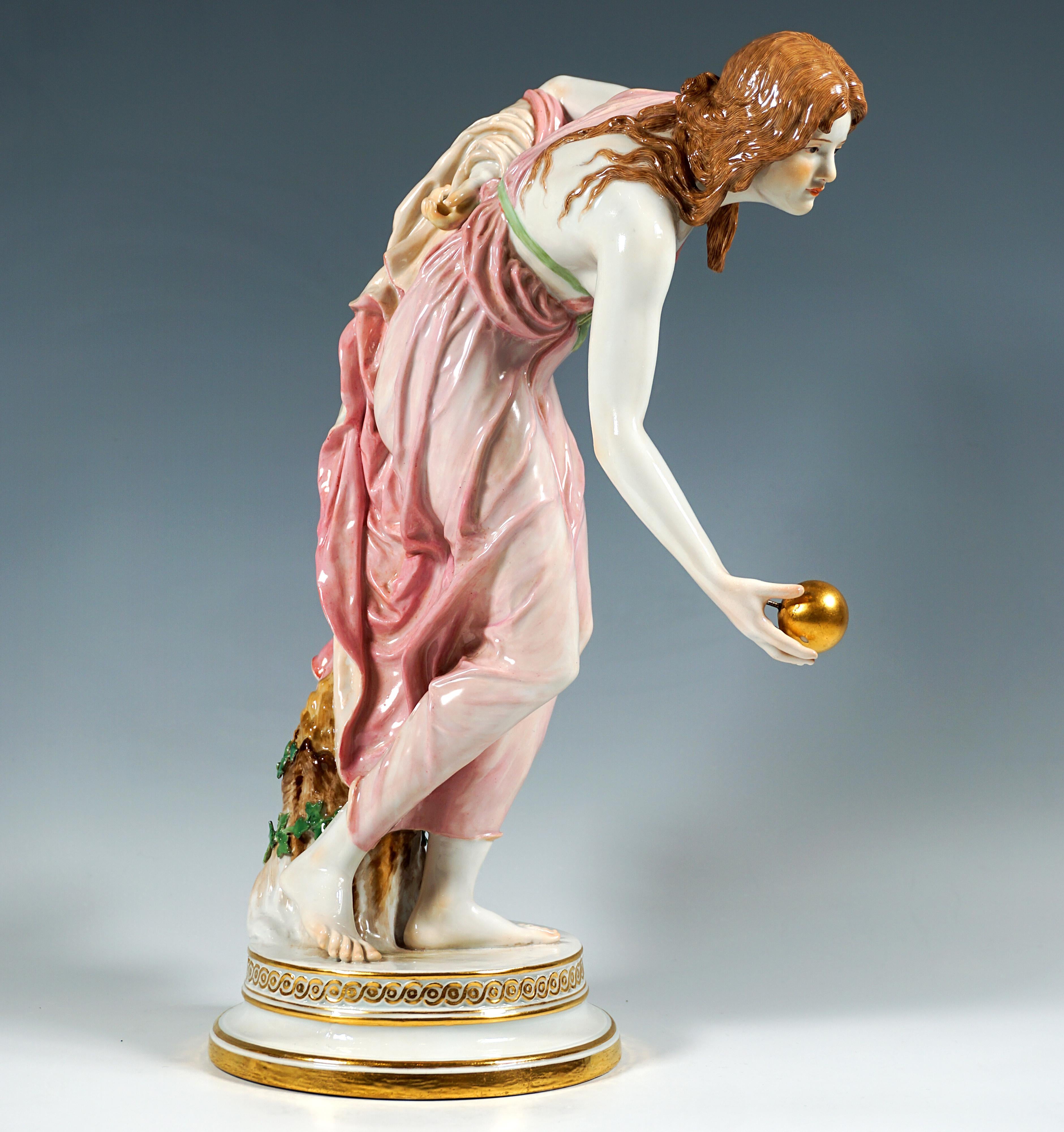 Representación extremadamente decorativa y totalmente escultórica de una belleza Art Nouveau con una túnica que cae suavemente, inclinada hacia delante para lanzar una pelota dorada, con el antebrazo izquierdo sujetando el dobladillo trasero del