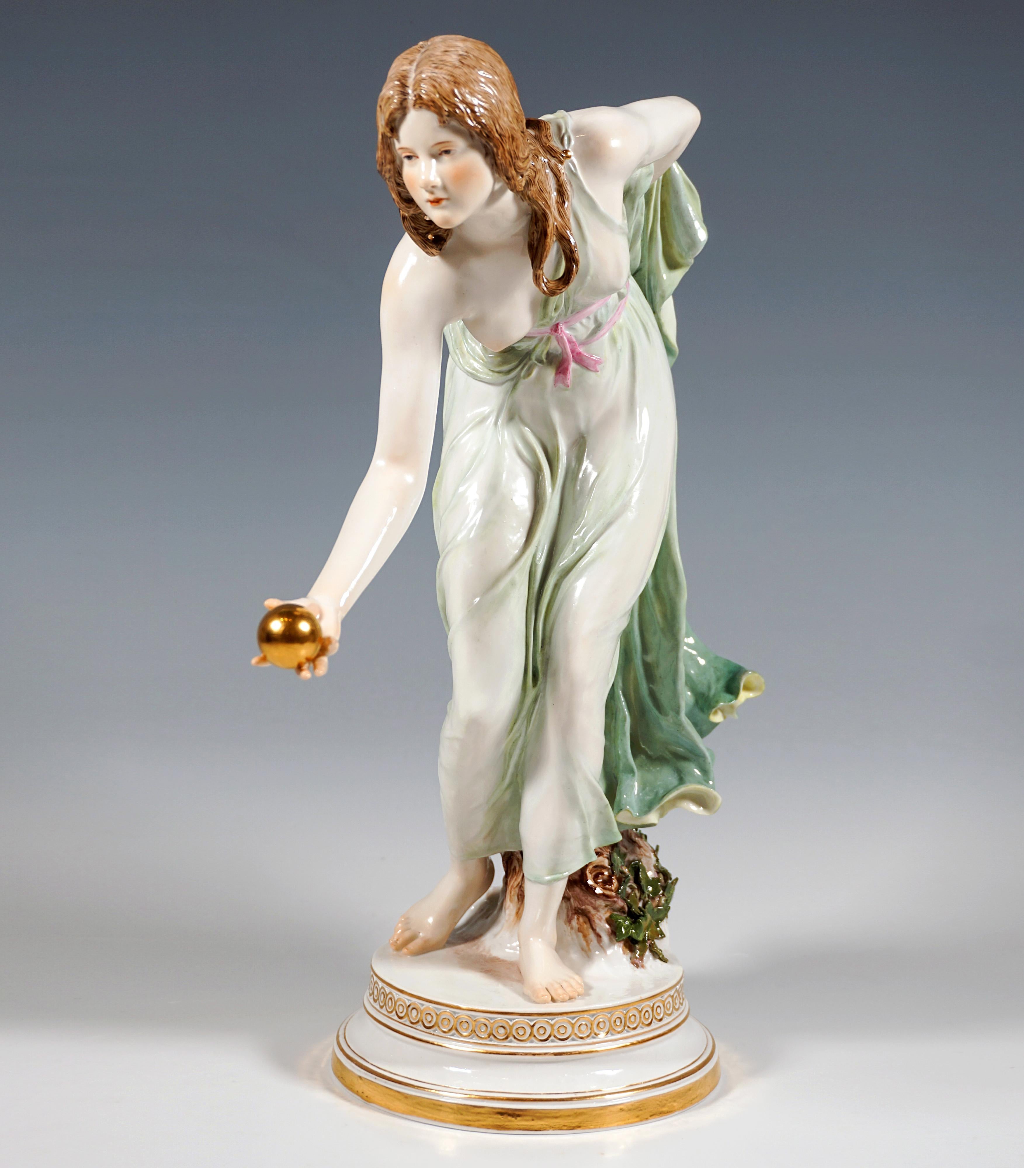 Représentation extrêmement décorative, entièrement sculptée, d'une beauté Art nouveau vêtue d'une robe tombant doucement, inclinée vers l'avant pour lancer une balle d'or, l'avant-bras gauche tenant l'ourlet arrière de la robe dans son dos.
La