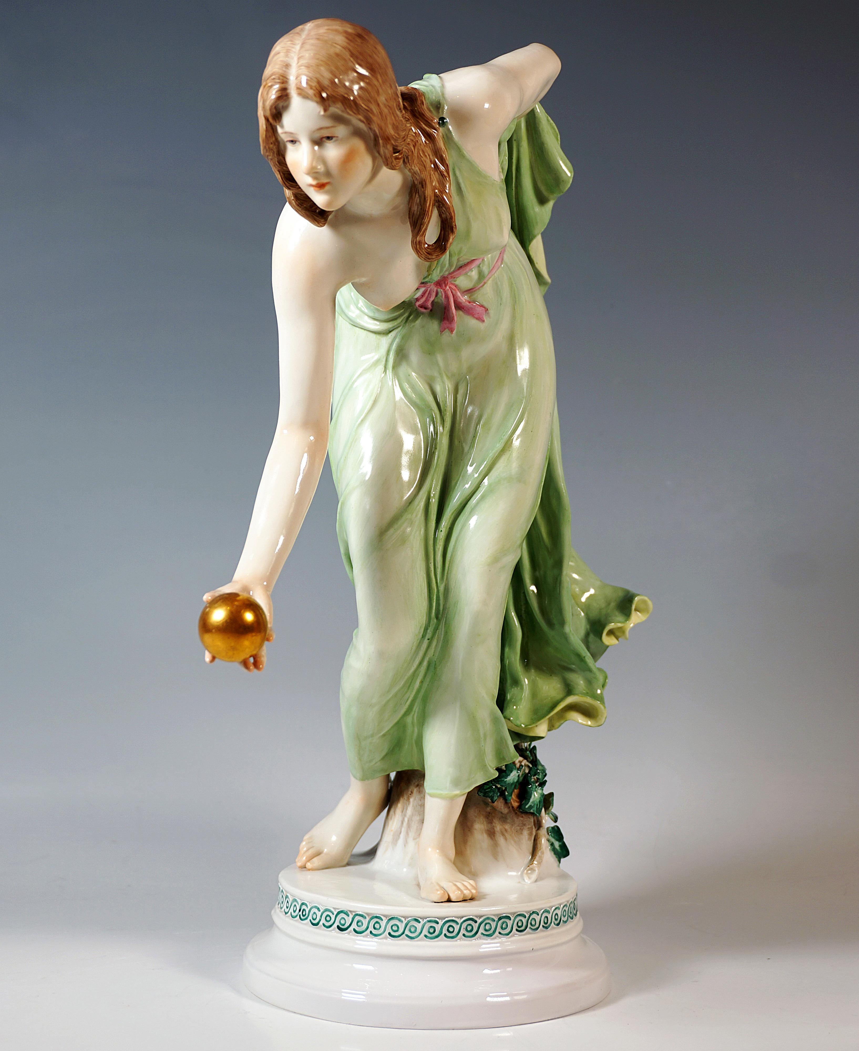 Extremely decorative, fully sculptural representation of an Art Nouveau beauty in a softly falling robe, tilted forward to throw a golden ball, with the left forearm holding the back hem of the dress on her back.
The figure is supported by a tree