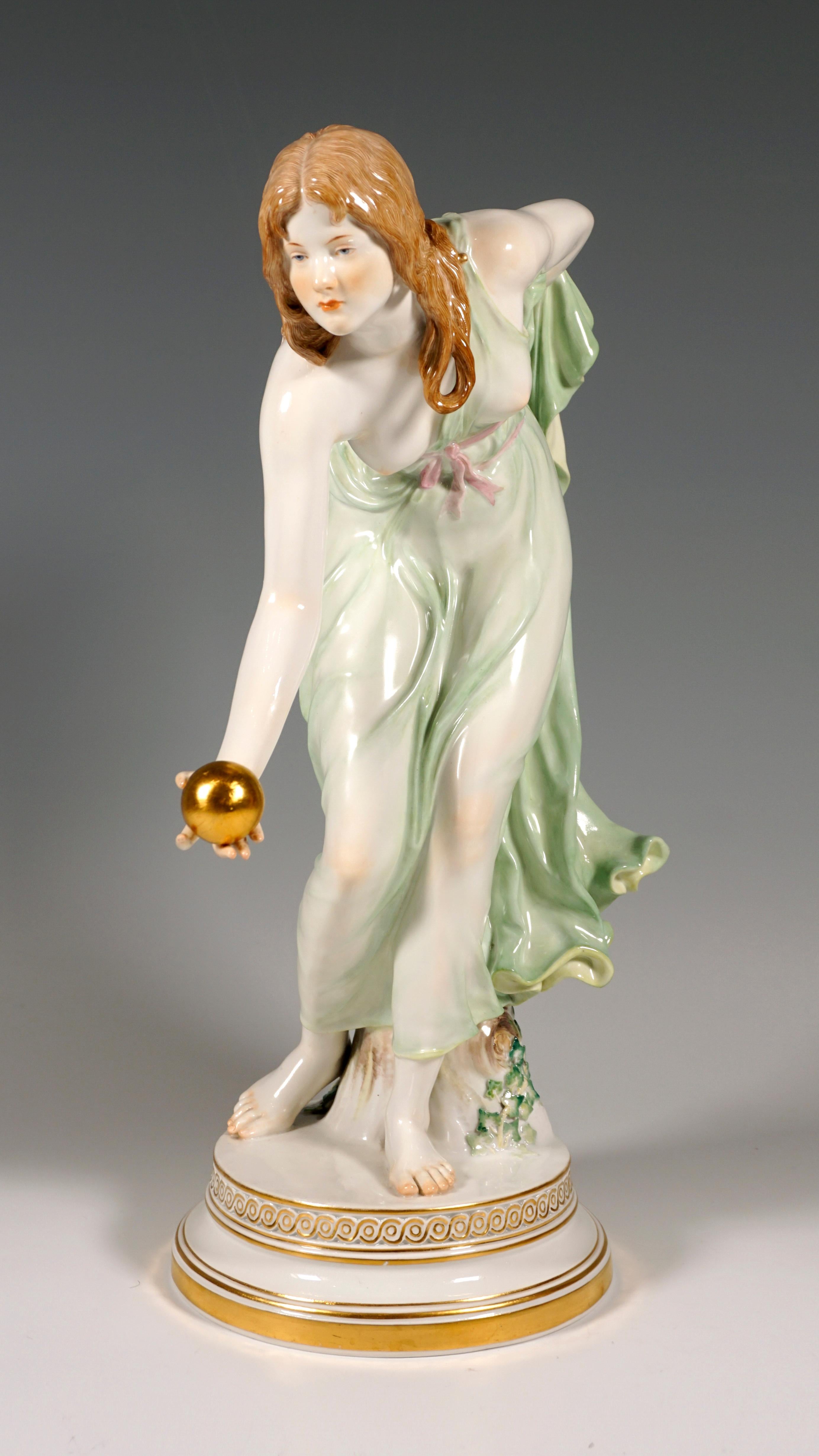 Extremely decorative, fully sculptural representation of an Art Nouveau beauty with a bared breast, in a softly falling robe, tilted forward to throw a golden ball, with the left forearm holding the back hem of the dress on her back.
The figure is