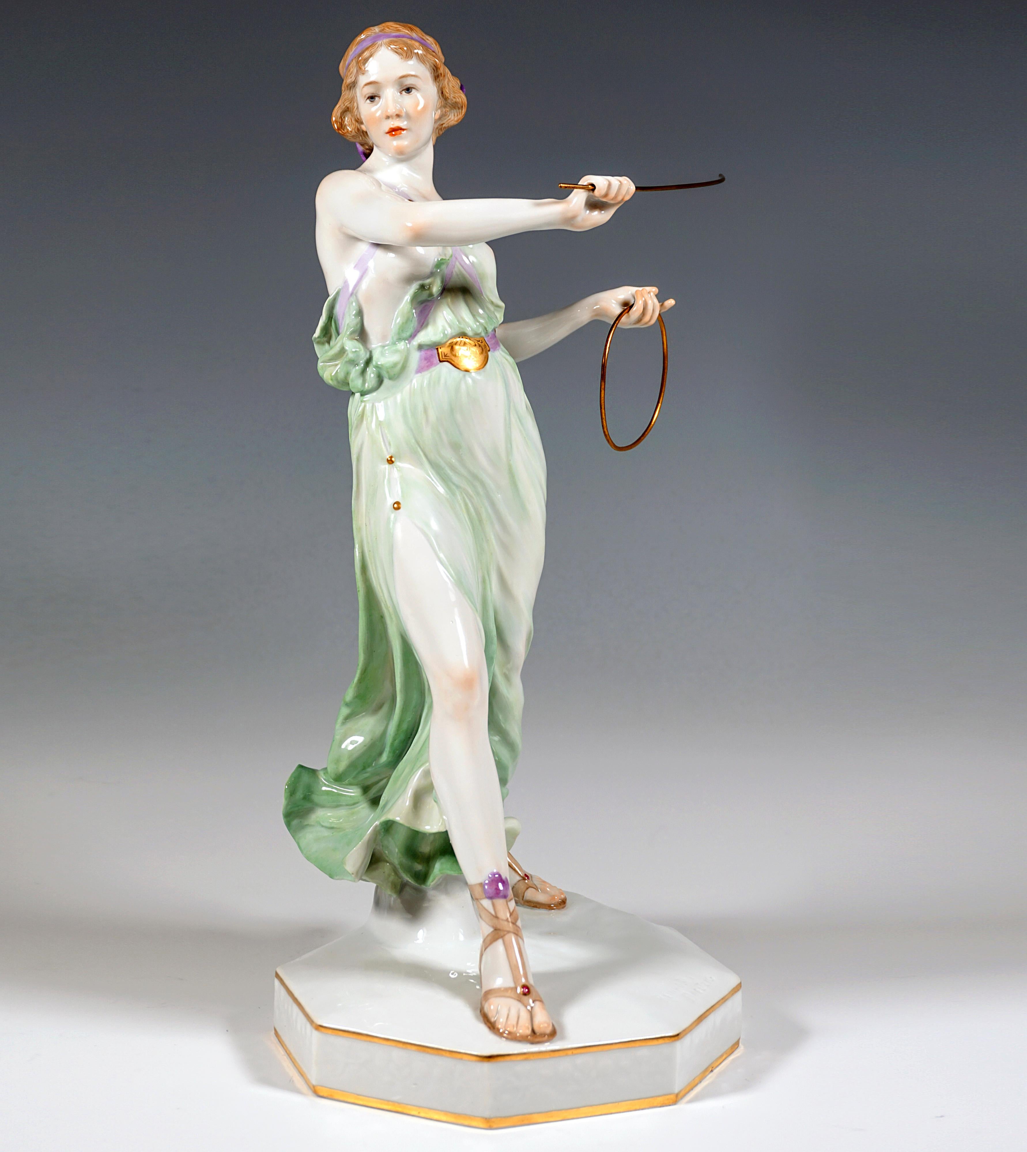 Extremely decorative full-sculptural representation of an Art Nouveau beauty in softly falling robe held together by straps on the upper part of the body with partially exposed breast, in graceful striding pose, the upper part of 
the body slightly