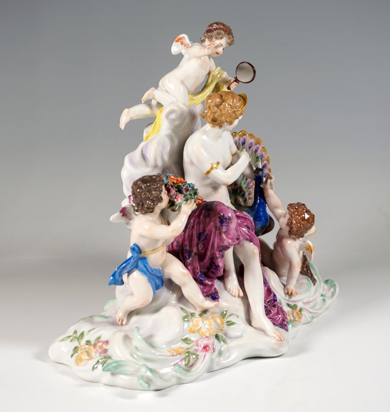 Very rare Meissen Porcelain group of the early 20th century:
Juno, the Roman goddess of the air (Greek Hera), as a young woman with her hair pinned up, covered only with a cloth, sitting on a cloud, adorning herself with bracelets, next to her