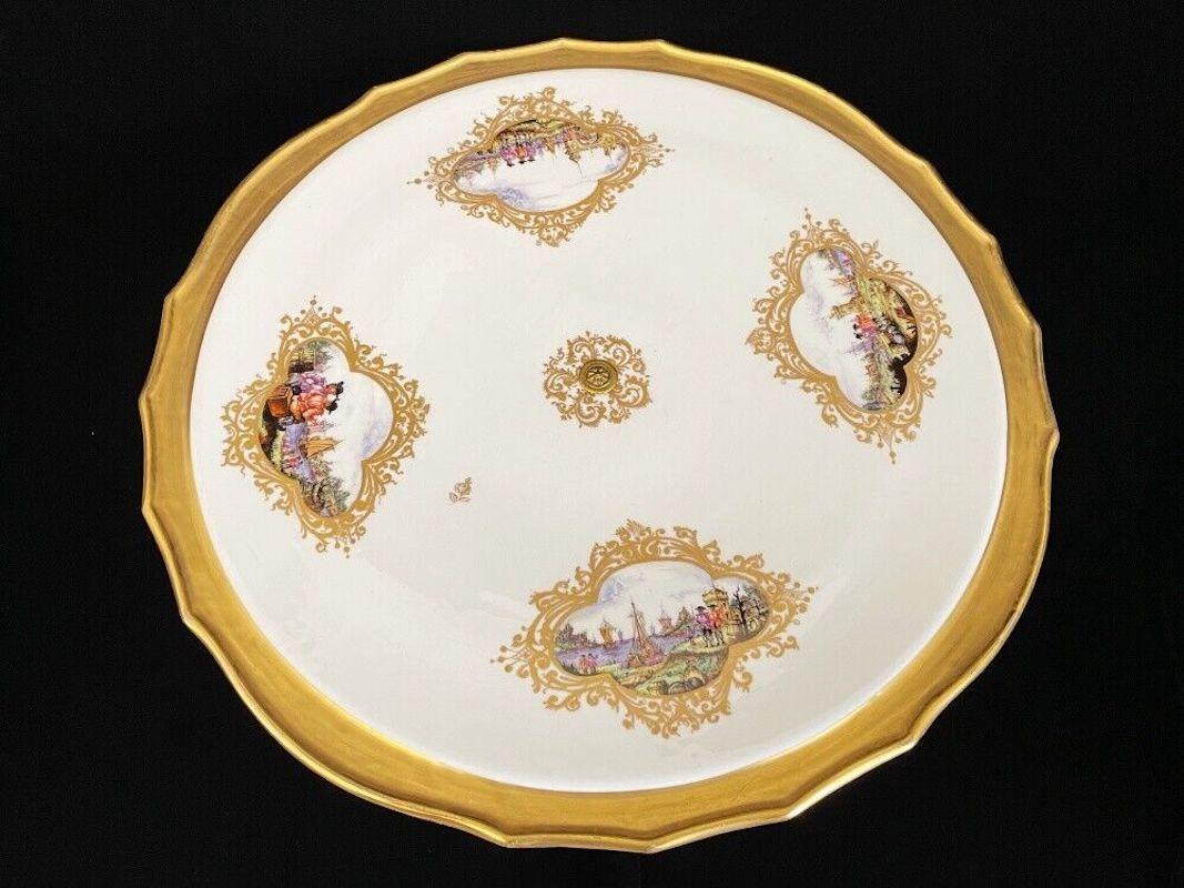 Outstanding Meissen centerpiece in a rare kind. The huge platter is mounted on a tripod with lions feet. Rich gilding surrounding four reserves depicting some Kauffauhrteiscenes. Very intense colours nice quality of painting.

