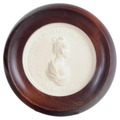 Meissen. Circular relief plaque in biscuit with female profile portrait. 1970s