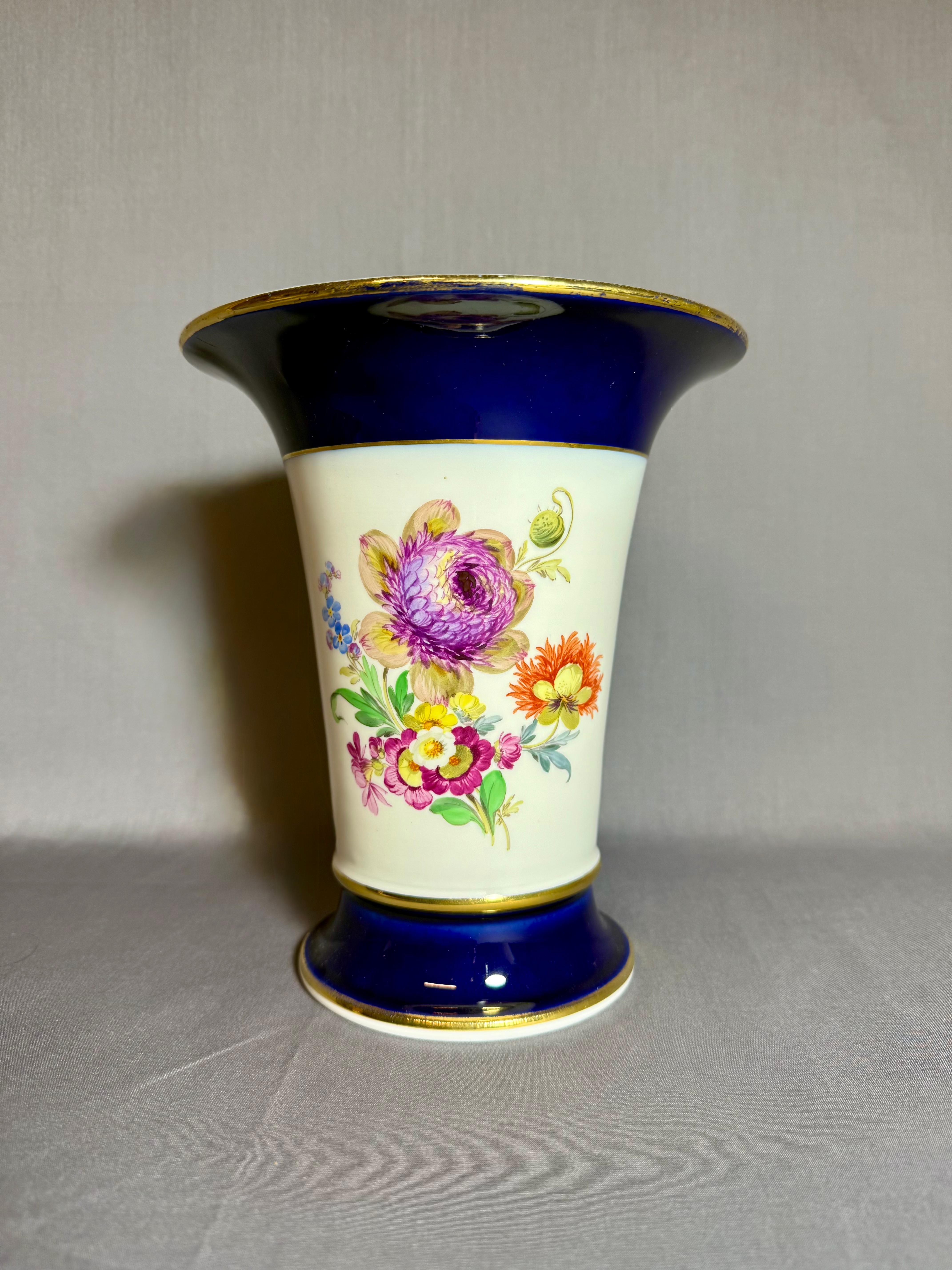 Jarrón de porcelana de Meissen, siglo XX, Alemania. Forma de trompeta, porcelana blanca. 
Decorado con azul cobalto y dorado.
 Pintado a mano con flores en el campo central. 
Dos hermosos ramos diferentes 
Sellado.
Altura: 19,5 cm ( 7,85