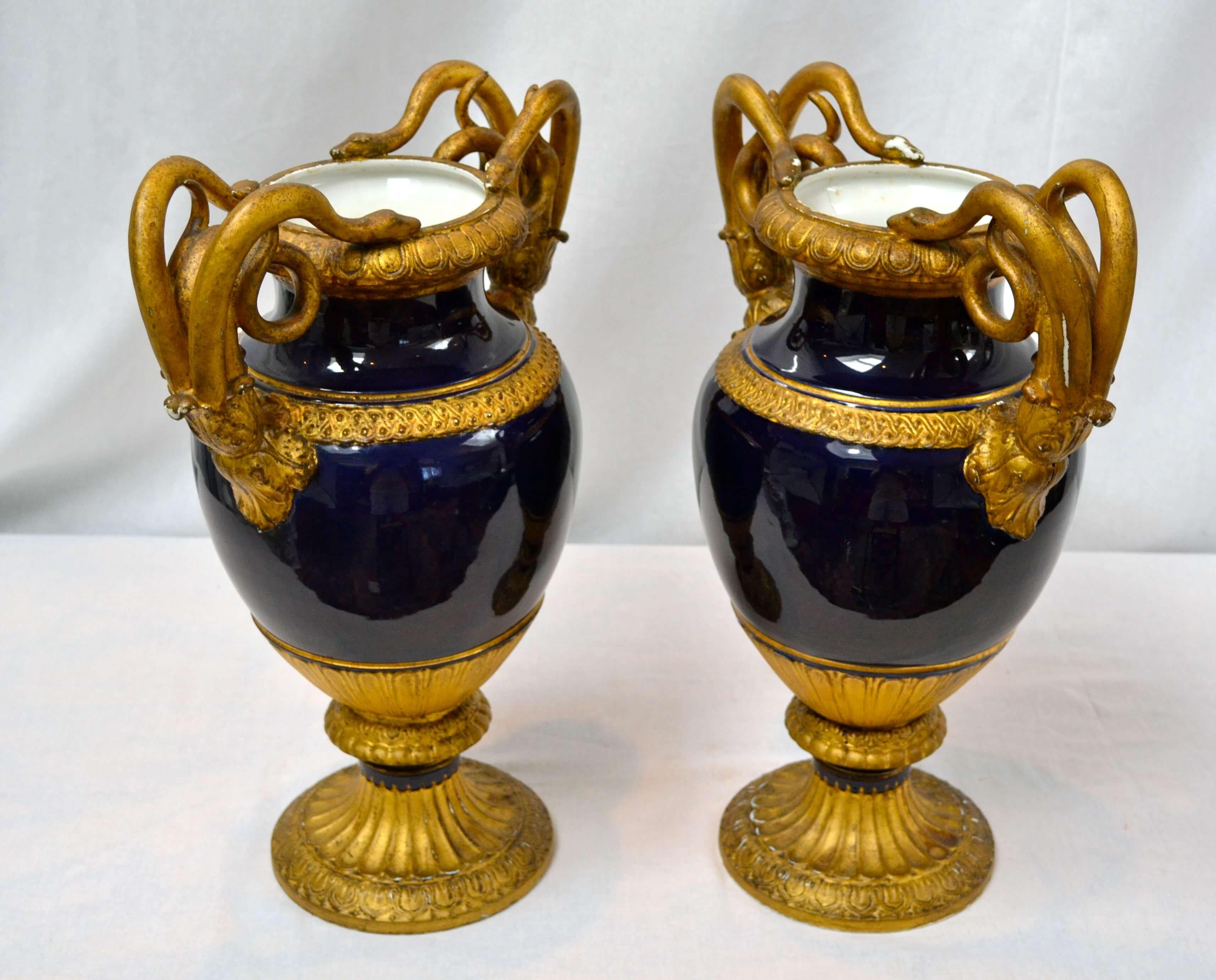 Neoclassical baluster form Meissen vases with gilt gadrooned rim flanked by paired coiled serpent handles and terminated with acanthus leaves above a band of VItruvian scrolls. Marked on the bottom with under glazed blue crossed swords. Some wear to