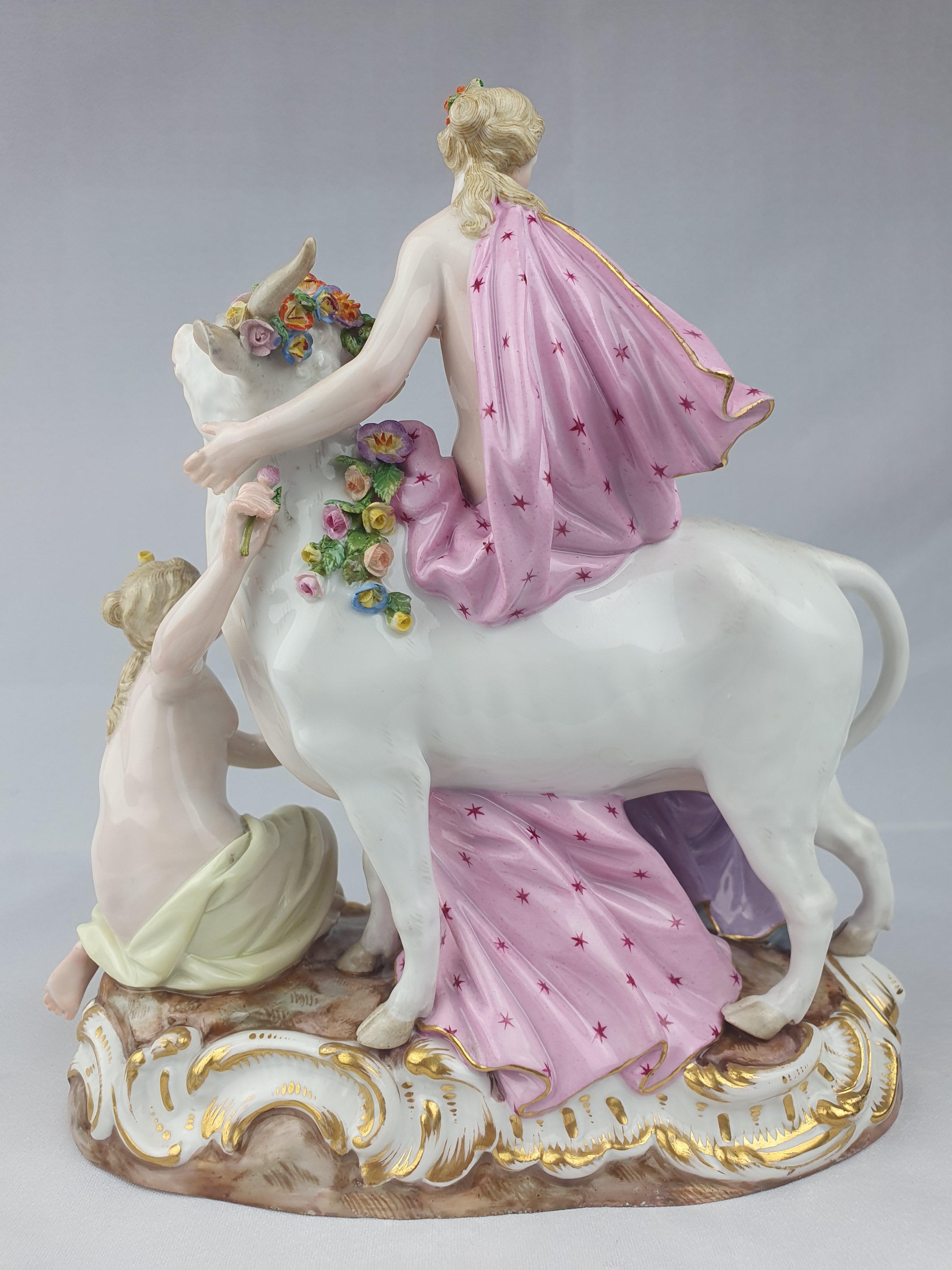 Meissen group of Europa and the Bull. Europa sitting on white bull with two female attendants sitting either side of her. The god Zeus has transformed himself in to a docile white bull in order to gain the confidence of Europa before he carries her