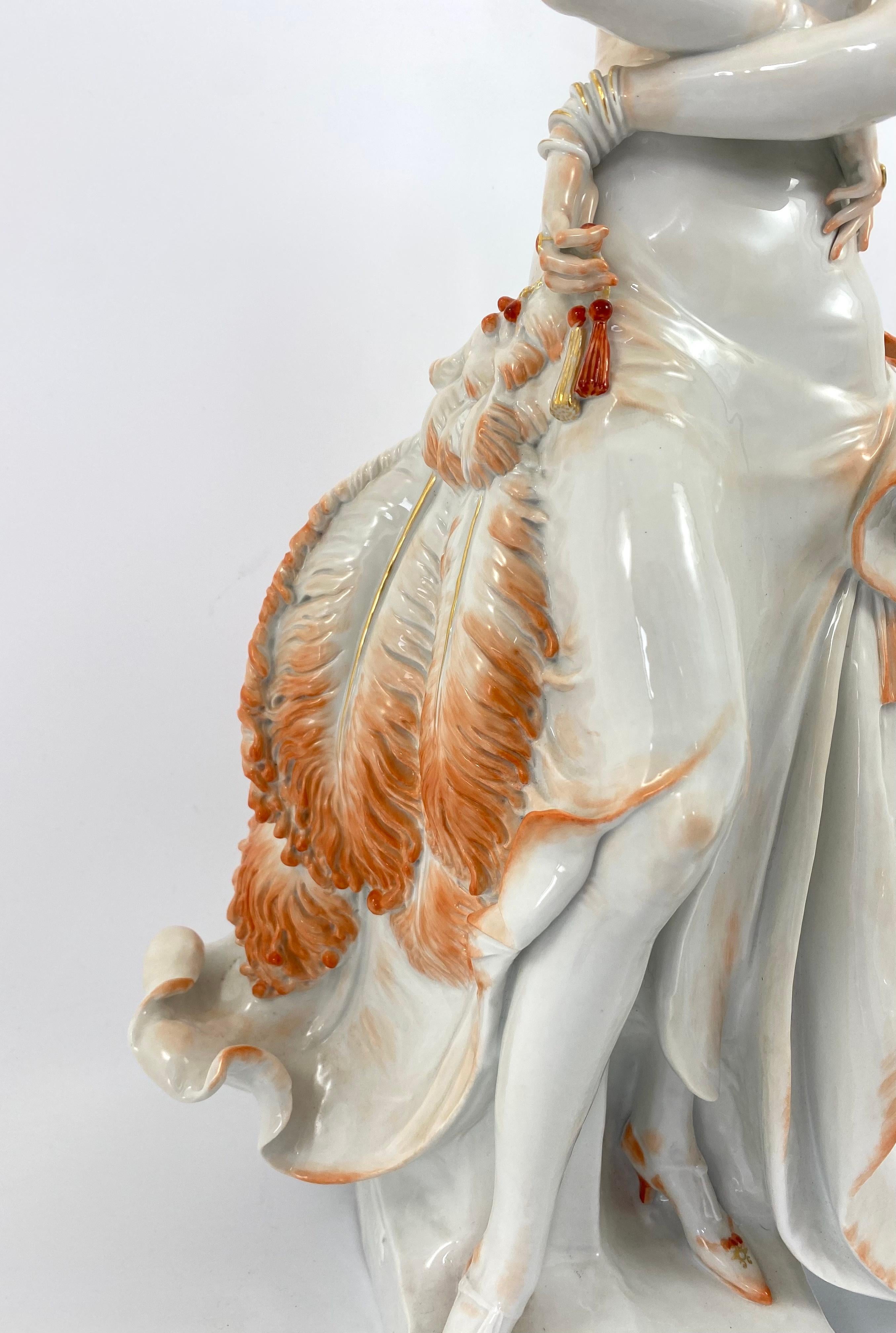 Meissen porcelain figure ‘Dame mit Faecher’, modelled by Professor Paul Sceurich, in 1929.
The elegant lady having short, waved hair, wearing an evening dress designed to accentuate her figure, and carries a large ostrich feather fan in her left