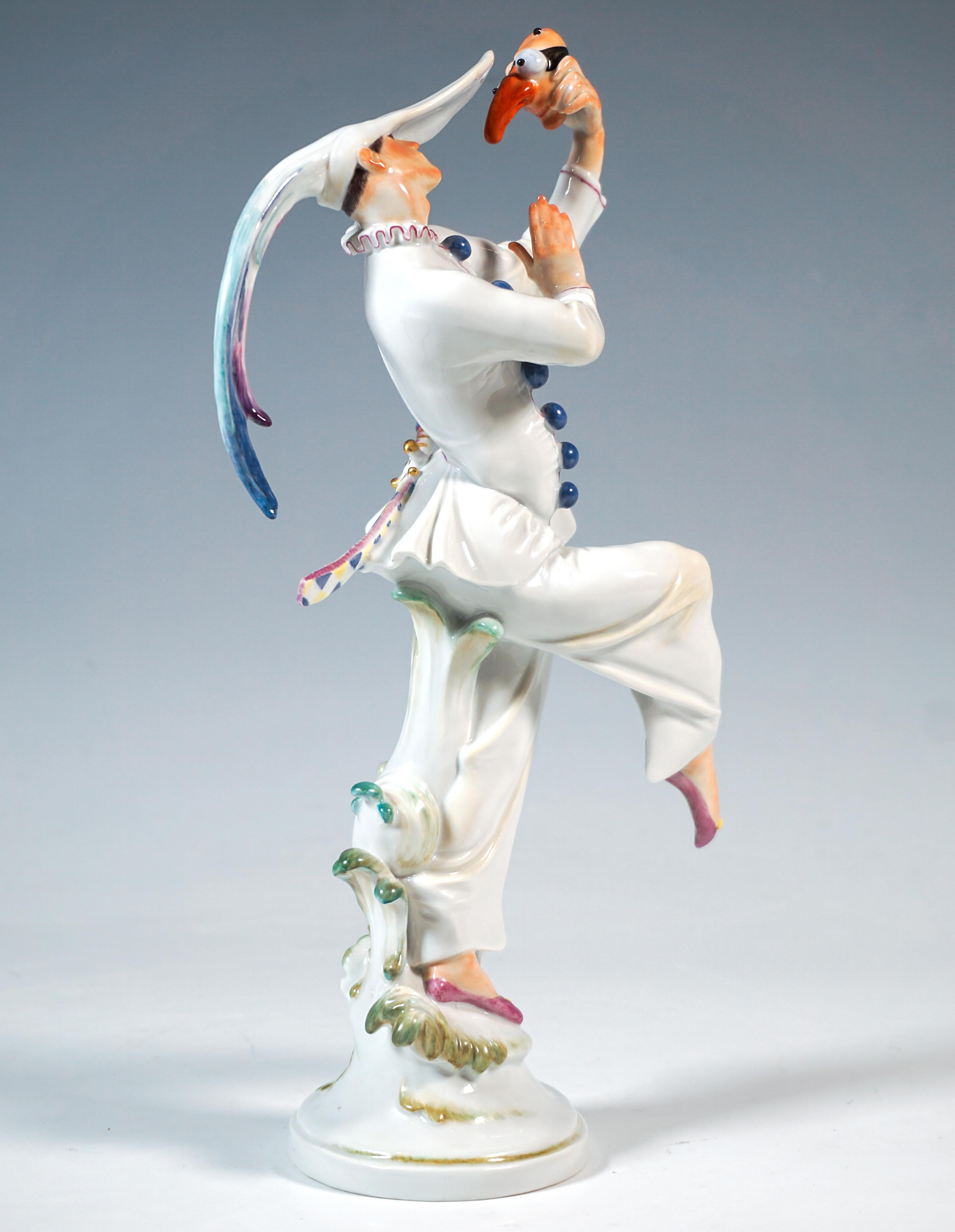 Figurine en porcelaine de Meissen :
Danseur debout sur une jambe, vêtu d'un costume Bajazzo blanc à glands bleus, coiffé d'une casquette caractéristique à visière extra-longue et à plumes de coq dépassant largement à l'arrière, levant la jambe