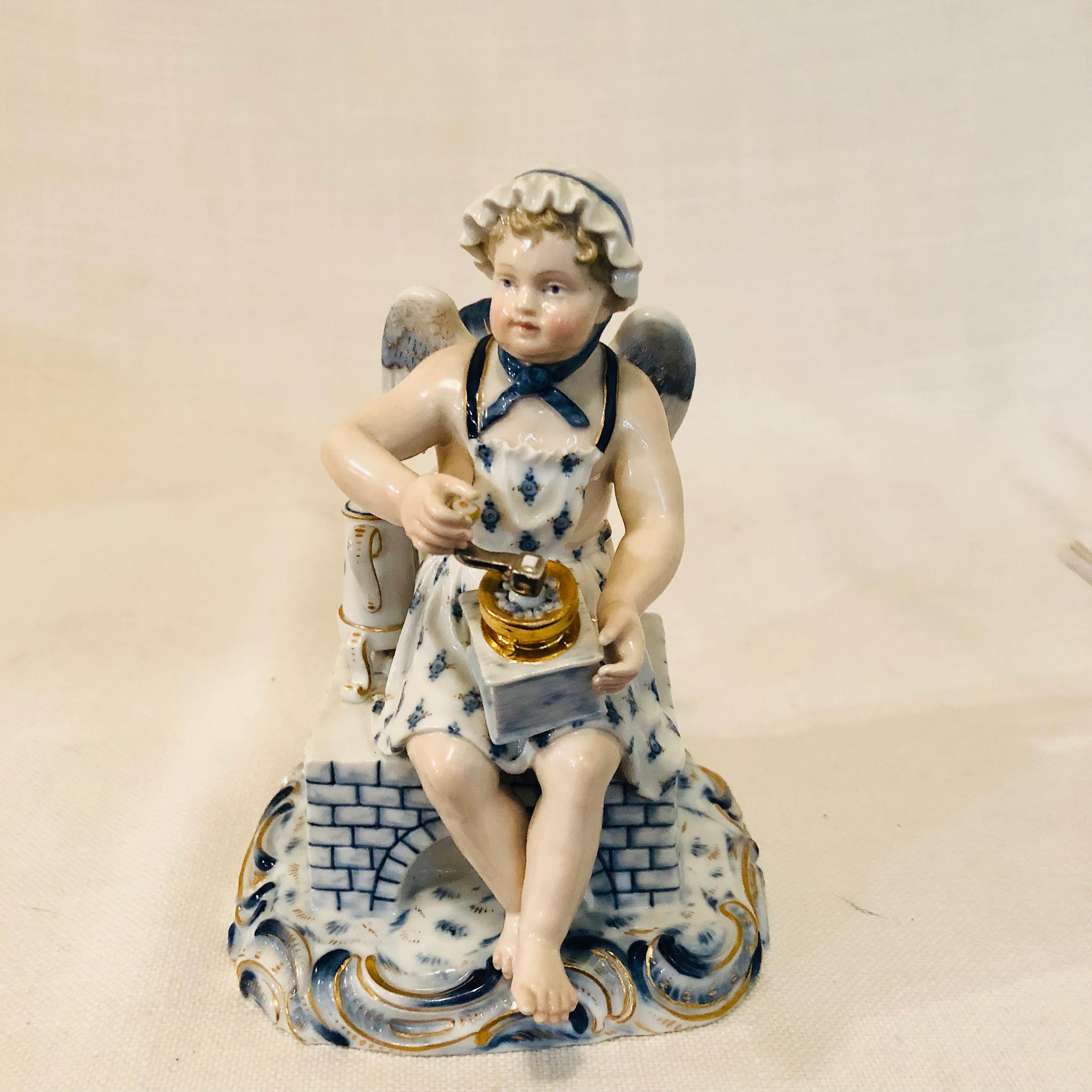 This is a very charming antique Meissen figurine of a boy angel with wings sitting on his stove grounding coffee to put in his coffee pot. The figurine is dark blue cobalt and white. It is in amazingly good antique condition. If you are either a