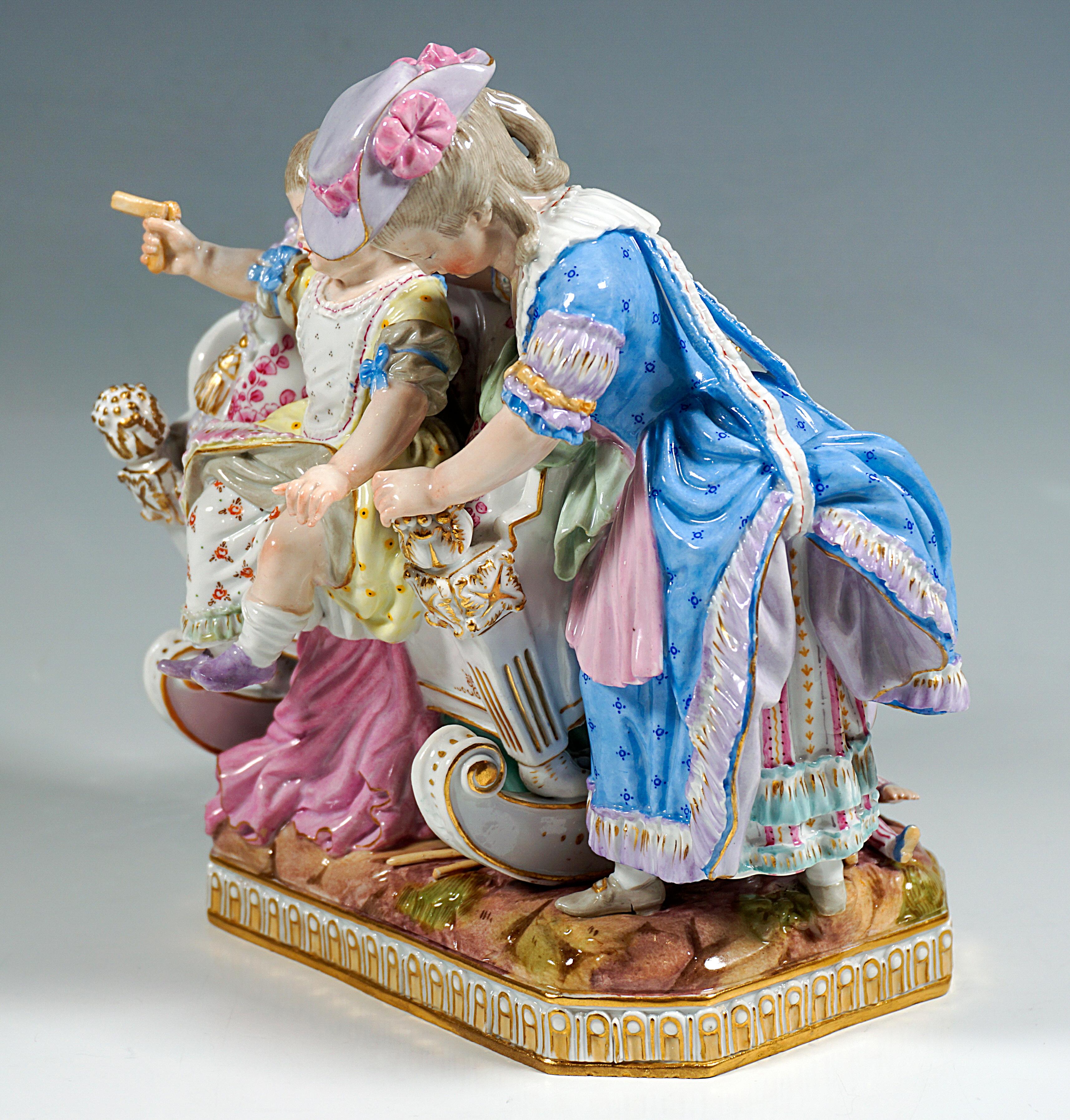 Rococo group of children: The older girl in dress and hat helping her little sibling with ratchet in hand from the cradle to play together, blankets and toys are spread out on the floor.
Very elaborate and loving design of the details.
The group