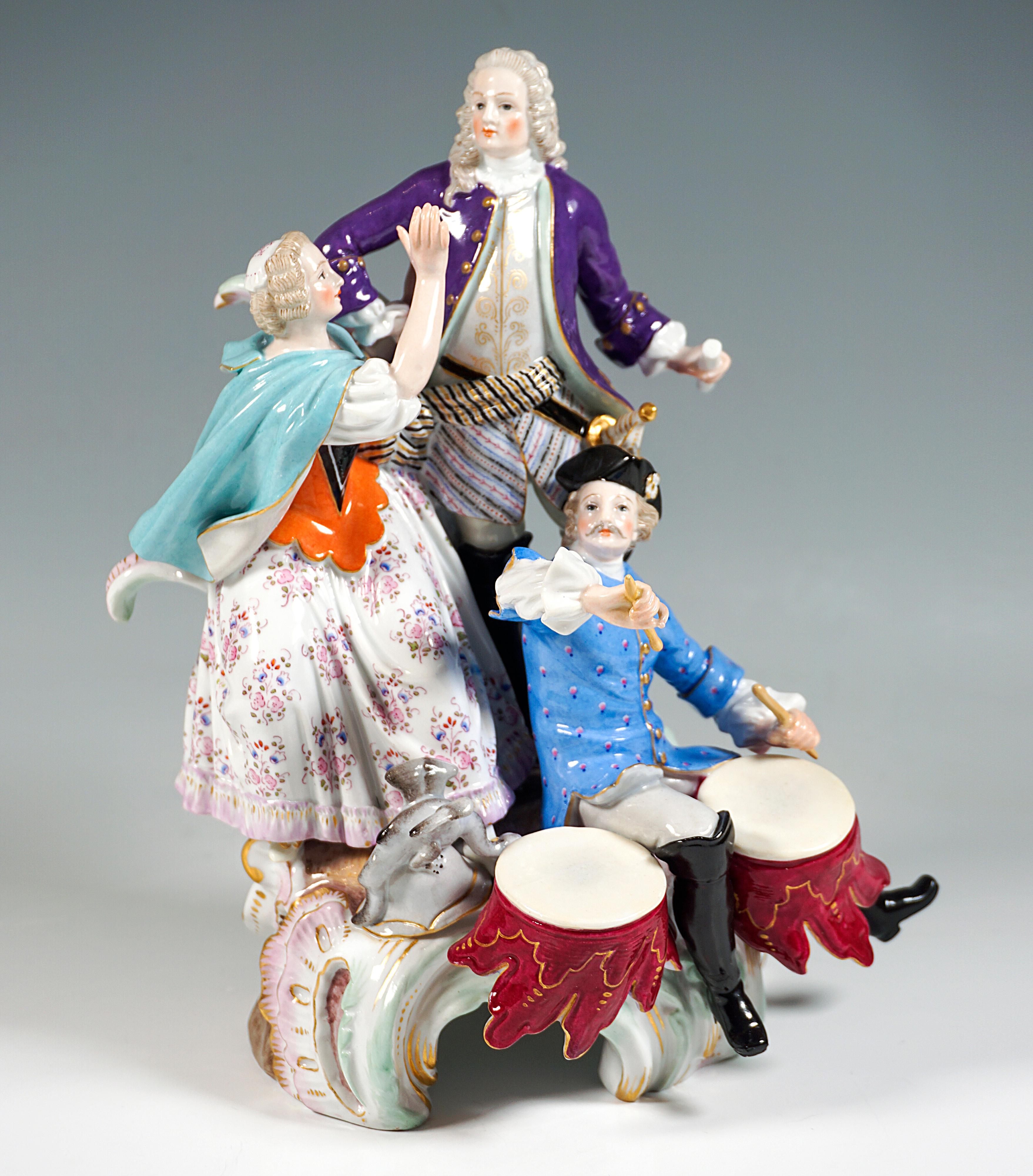 Exceptional Meissen porcelain group:
On rock pedestal fixed with large rocailles in the foreground sitting musician with tricorn, frock coat over wide shirt, white pants and high boots beating two timpani, behind him the lovers: the proud officer