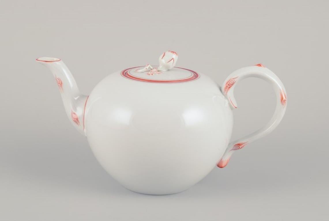 Meissen, Germania. 
Teiera Art Decor in porcellana decorata con finiture rosso corallo. 
Un pomello del coperchio a forma di bocciolo di rosa.
Approssimativamente negli anni '30.
Contrassegnato.
Terza qualità di fabbrica.
In ottime condizioni. Il